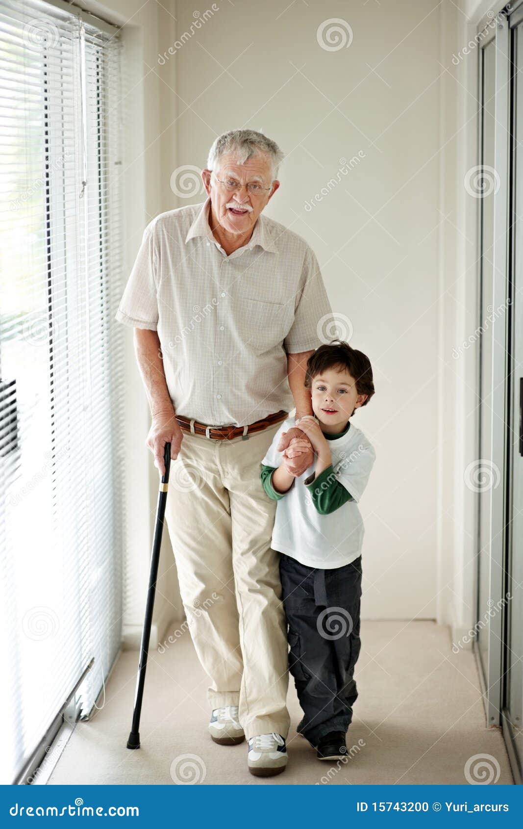 Stock Photo: Small boy helping a old man on walking stick. Image: 15743200