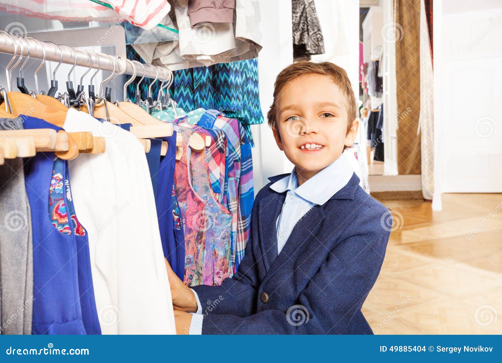 Small Boy in Navy Suit Standing Near Clothes Stock Photo - Image of ...