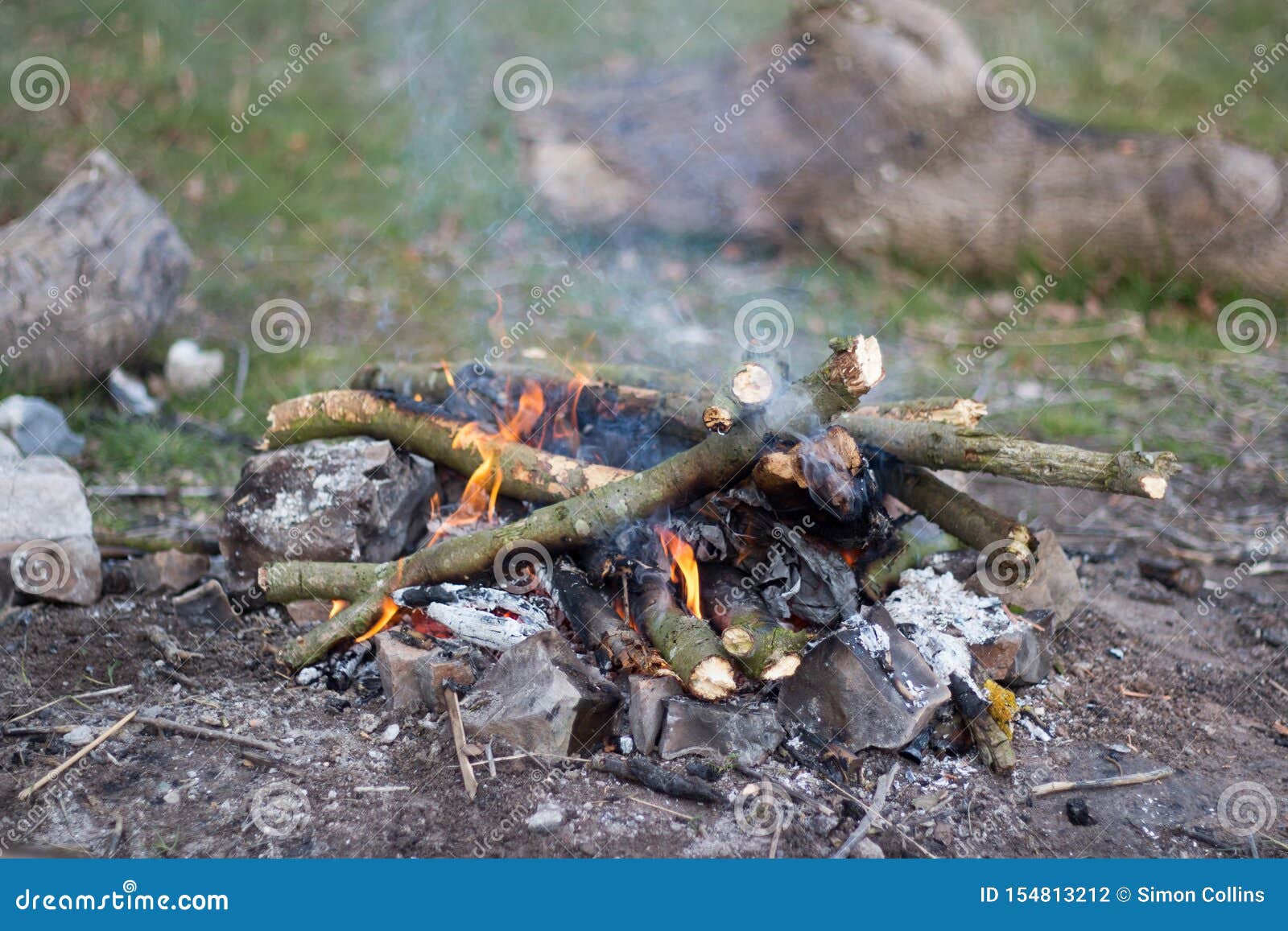 A Small Campfire Made Up of Twigs and Branches with Rocks Surrounding ...