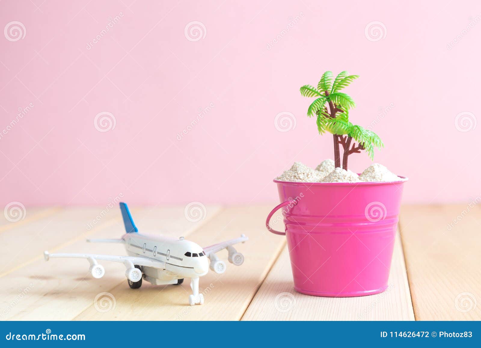 Small Can With Plastic Palm Tree And Aircraft Toy On Desk
