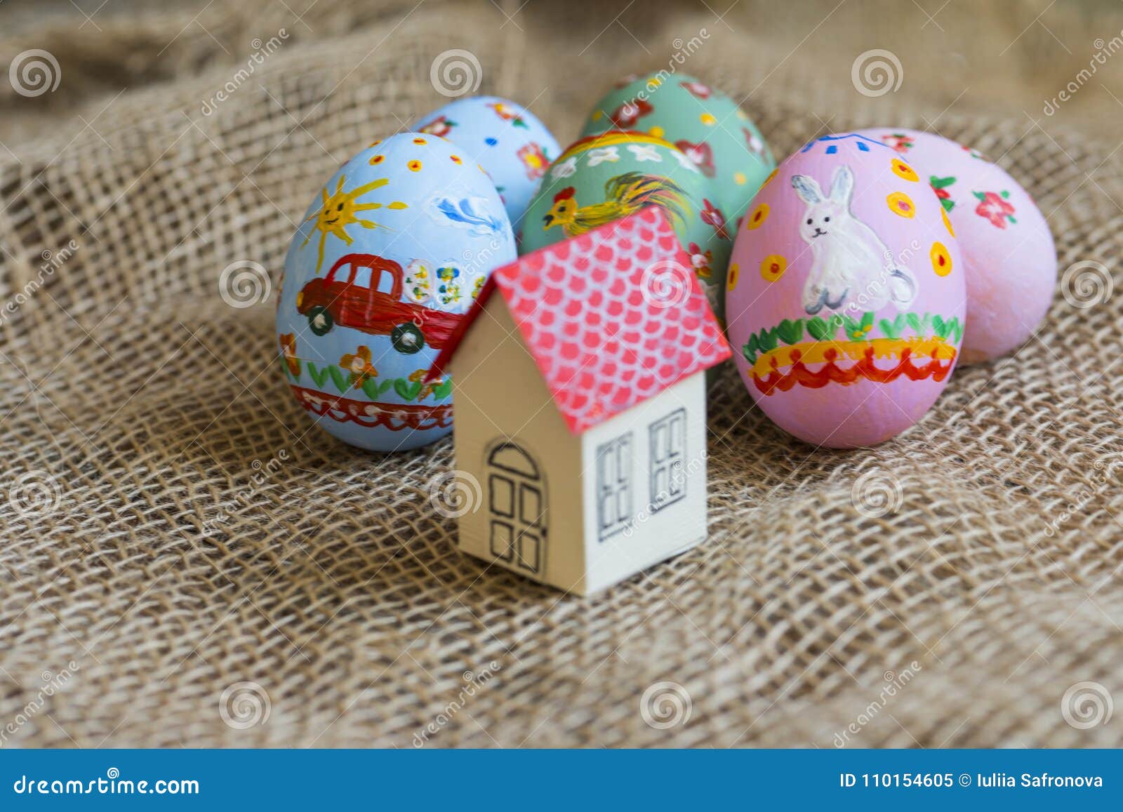 Small Cardboard House with a Red Roof, Easter Painted Eggs Stock Image