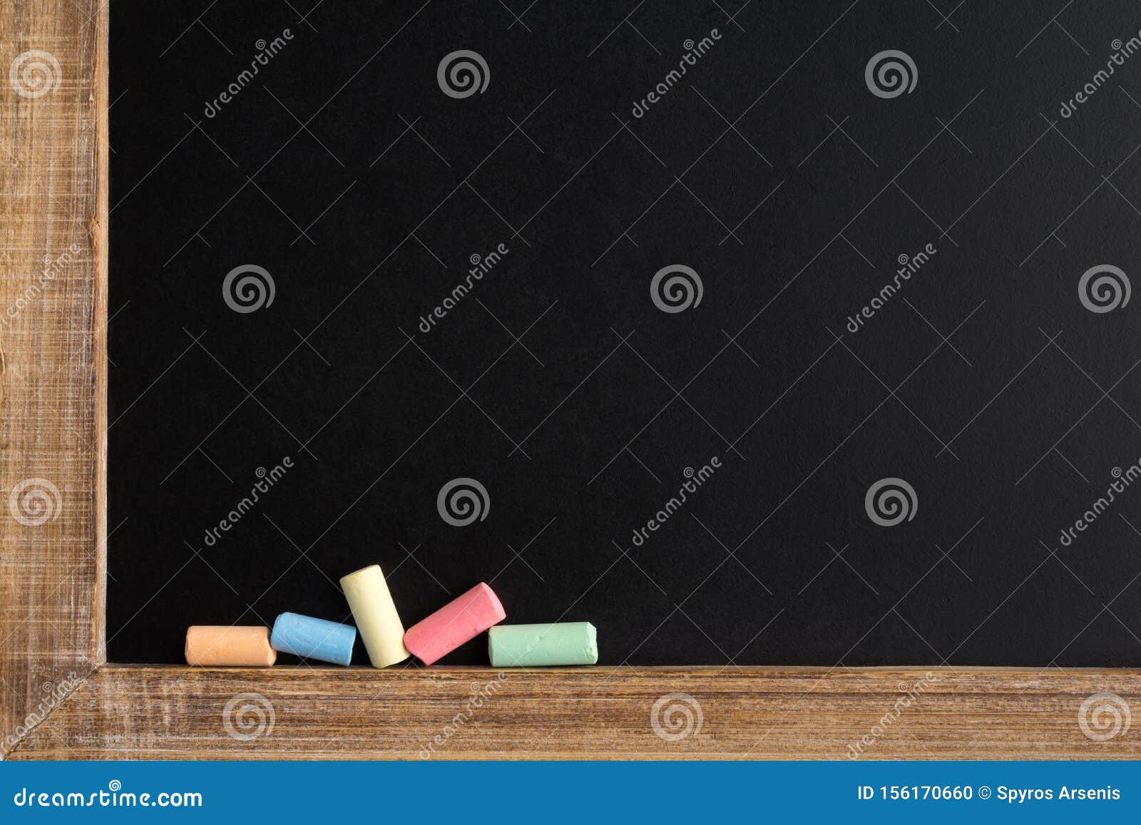 Small Chalk Pieces in Different Colors on a Blackboard Stock Photo