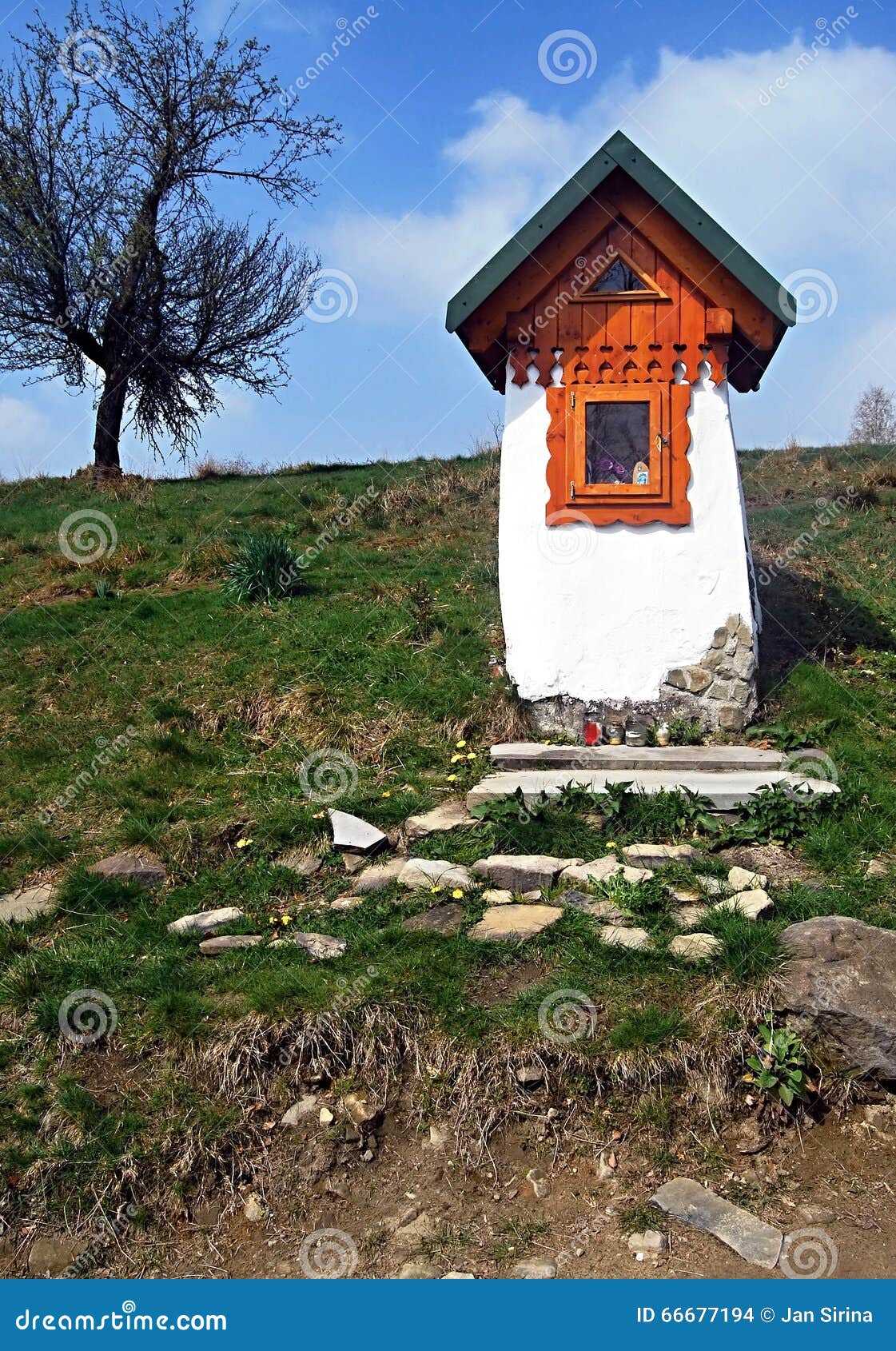 small chapel with tree and blue sky with clouds