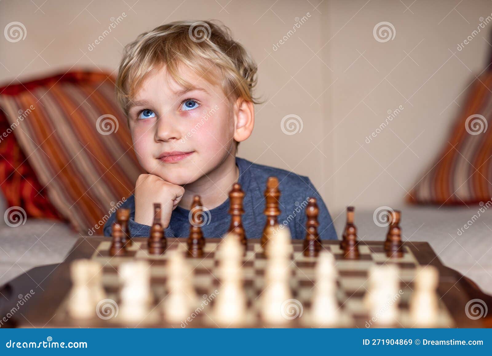 Small Child 5 Years Old Playing A Game Of Chess On Large Chess Board