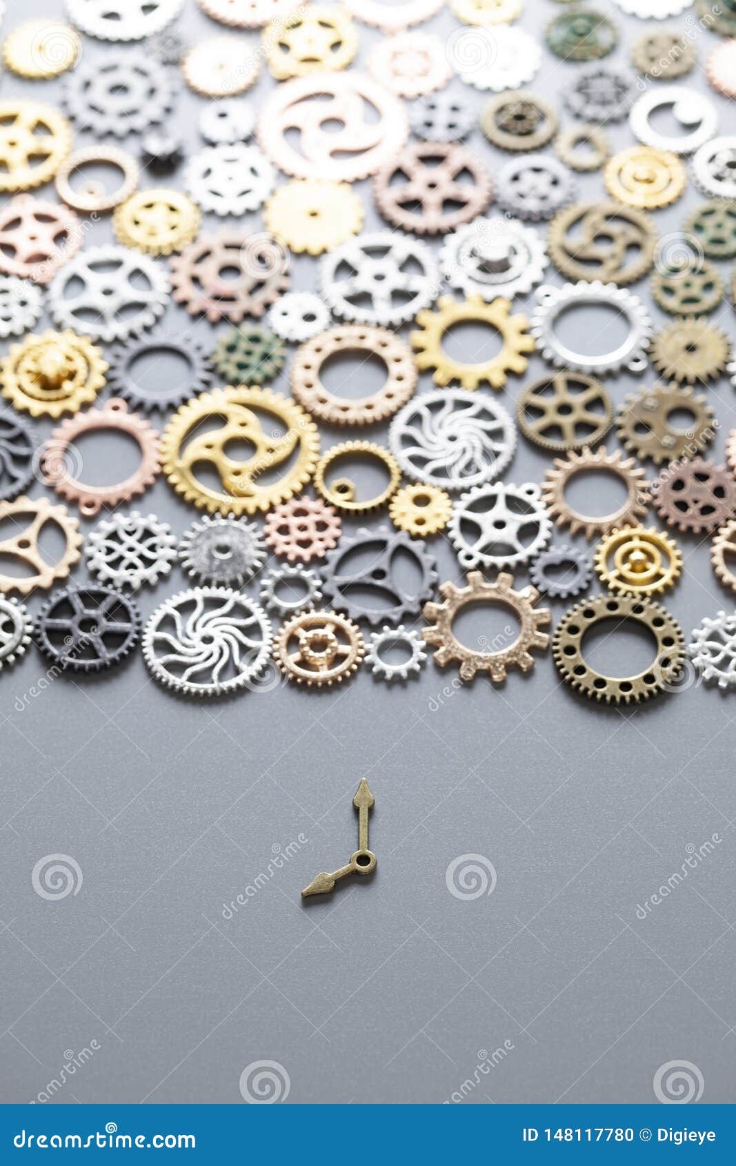 Small Clock Hands and Many Gears on a Gray Background Stock Photo