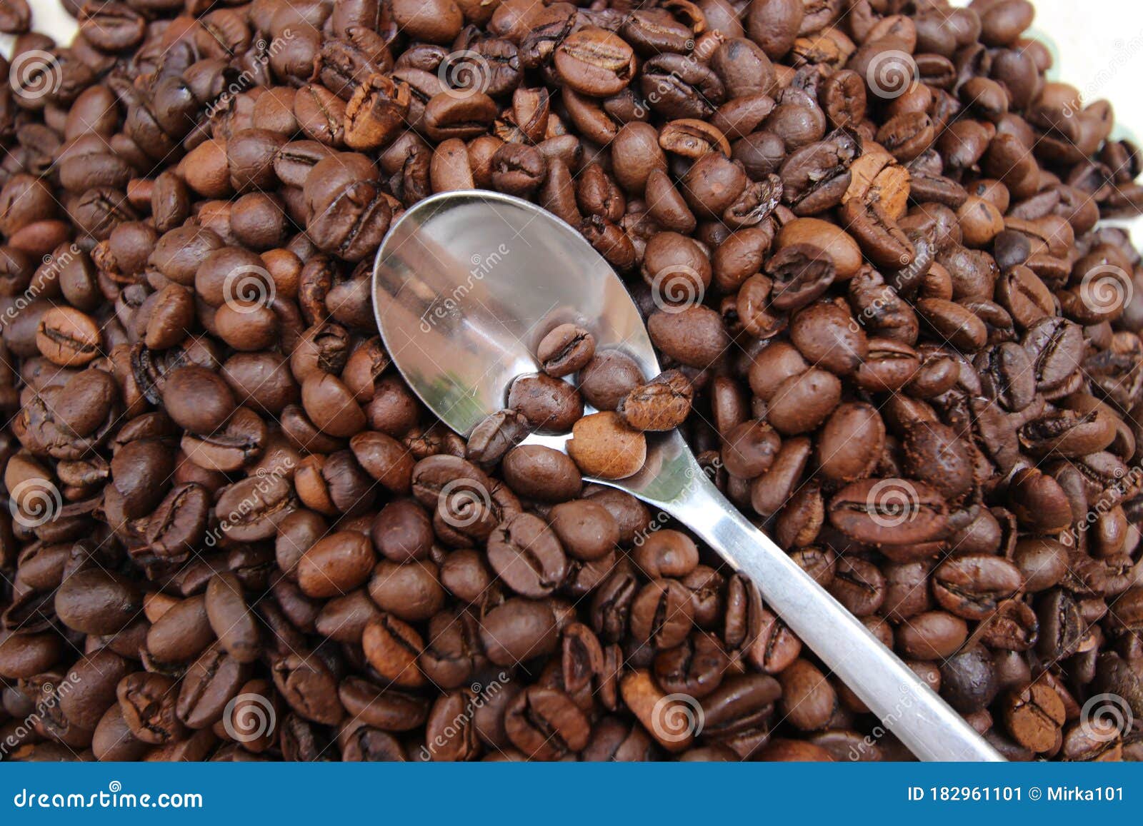 background with many coffee beans and metal spoon