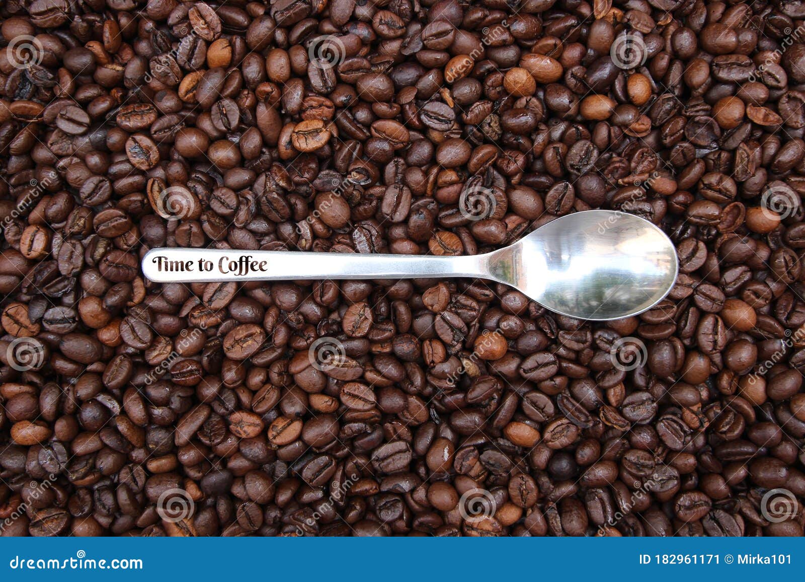 background with many coffee beans and metal spoon