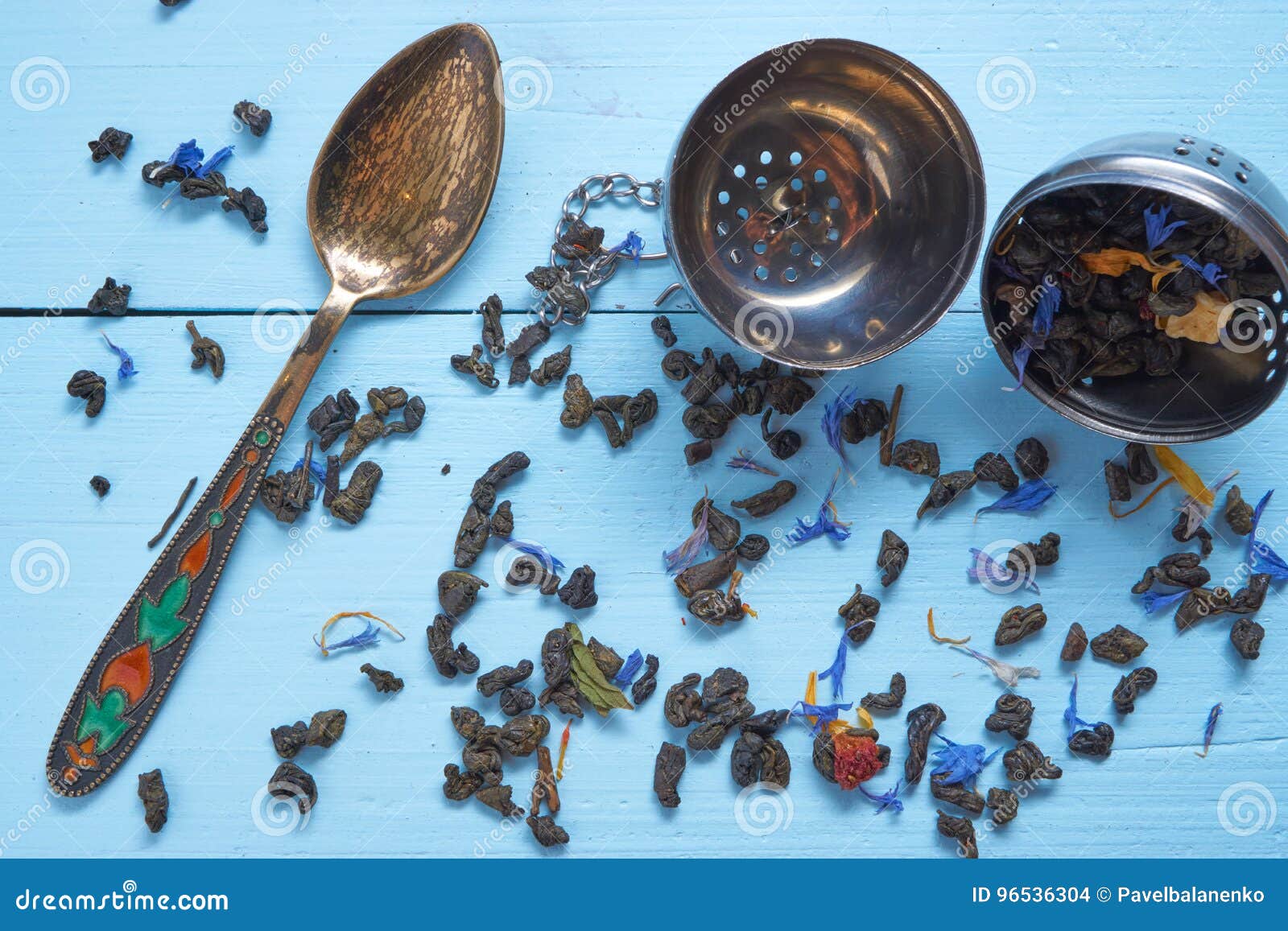 Small Decorative Teaspoon with Tea Leaves and Strainer Stock Photo