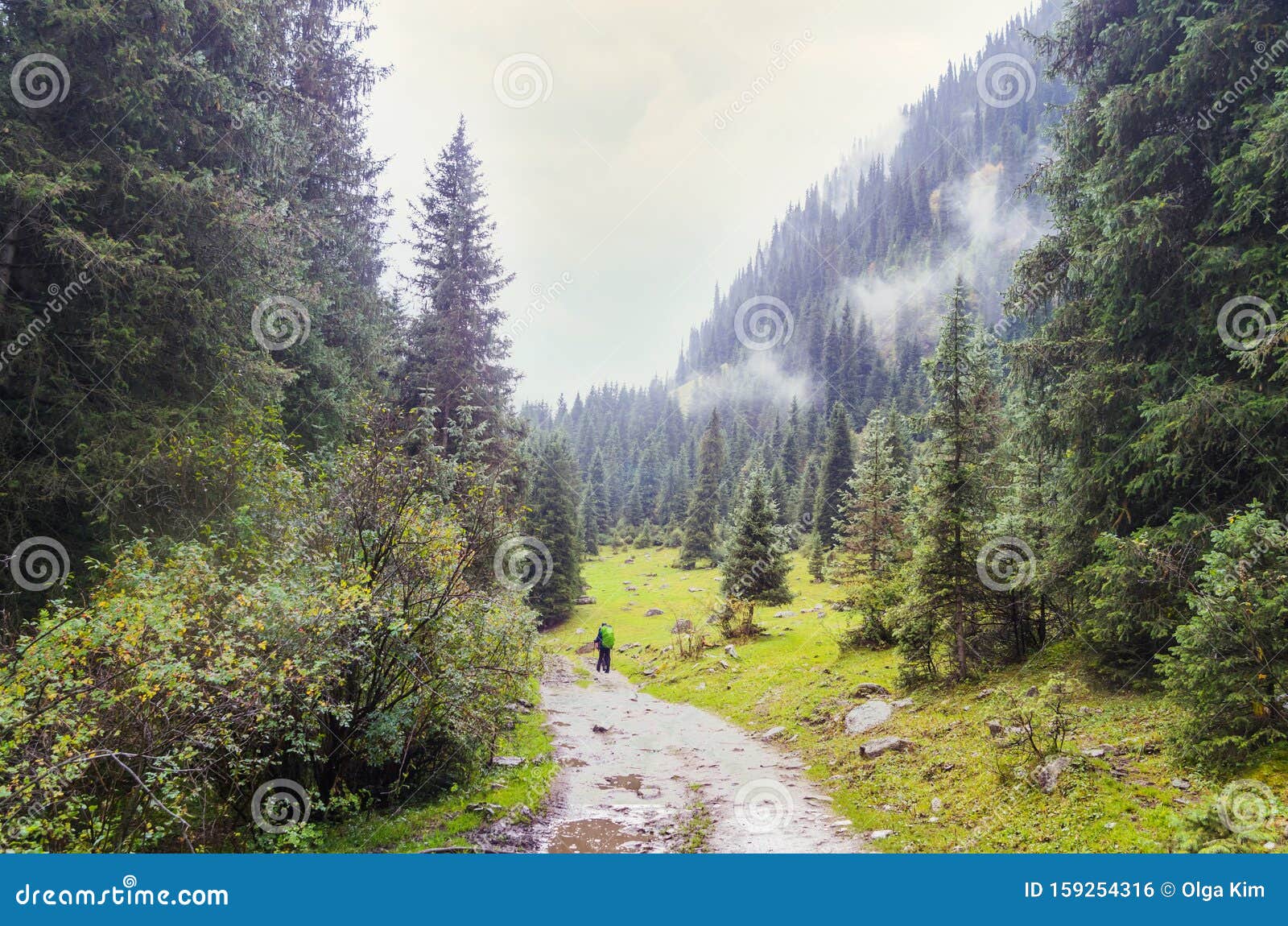 small figures of men walking along a mountain road