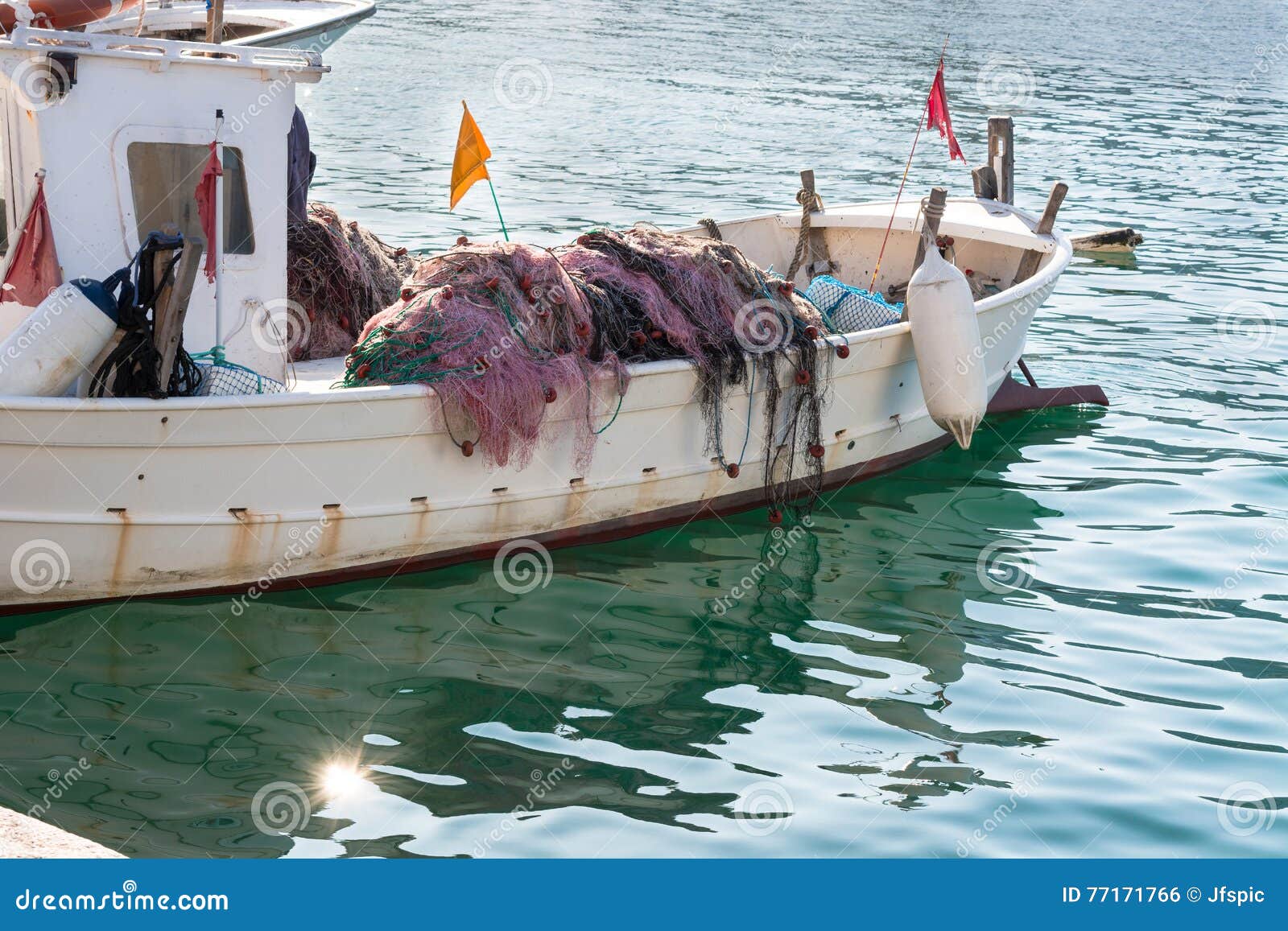 Small Wooden Fishing Boat With Fishing Net In Calm Water Stock