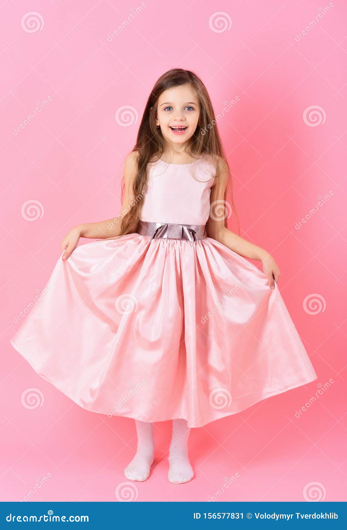 Vertically elegant child in a white dress. Little girl model Stock Photo -  Alamy