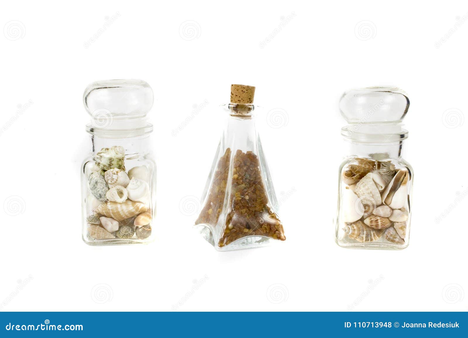 A Small Glass Container Full of Shells and Ambers on a White Iso Stock