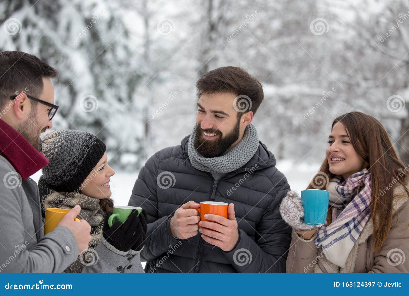 frineds with hot cups on snow