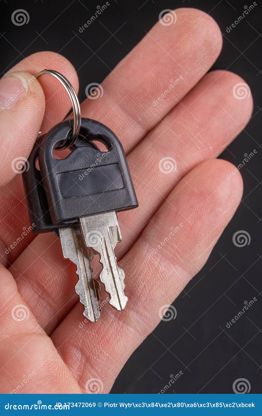 Small Keys with a Plastic Handle Kept in Your Fingers. Accessories for