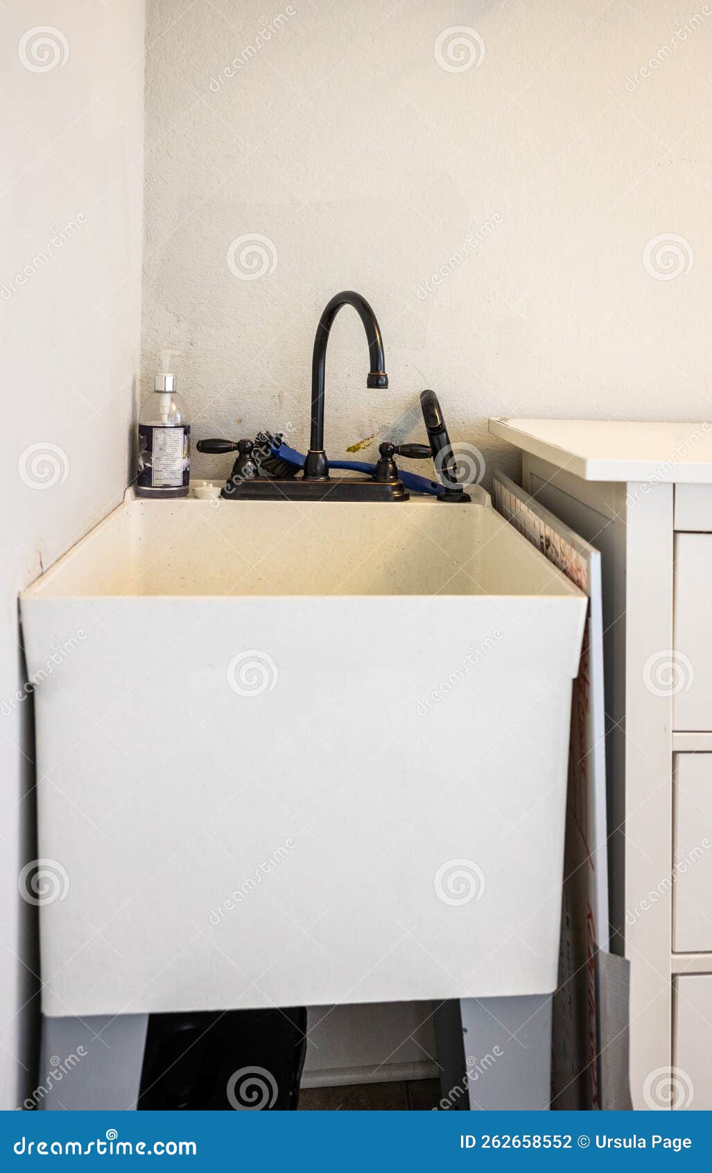 A Small Laundry Room Sink in the Corner of a New Construction Laundry