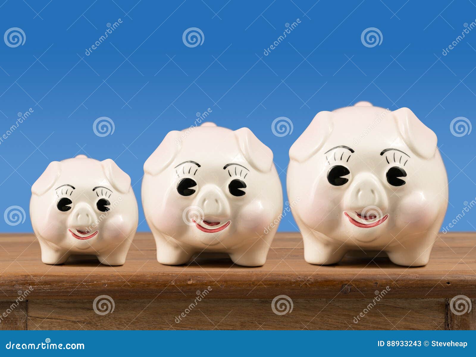 small medium and large piggy banks on shelf