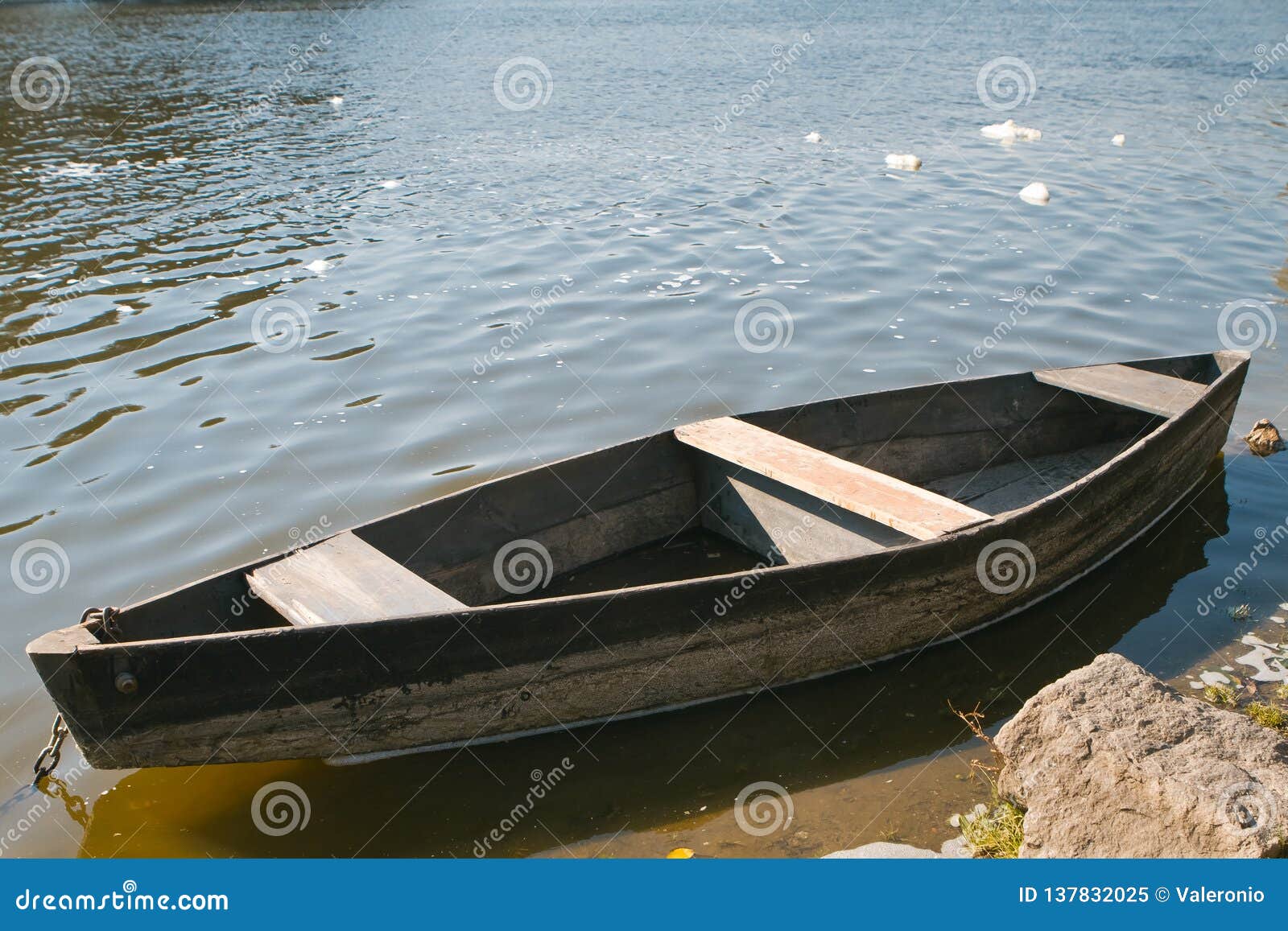 Small Old Wooden Fishing Boat on the Bank of a River, Bright Sunny Day,  Little Waves on Water Surface Stock Image - Image of background, light:  137832025