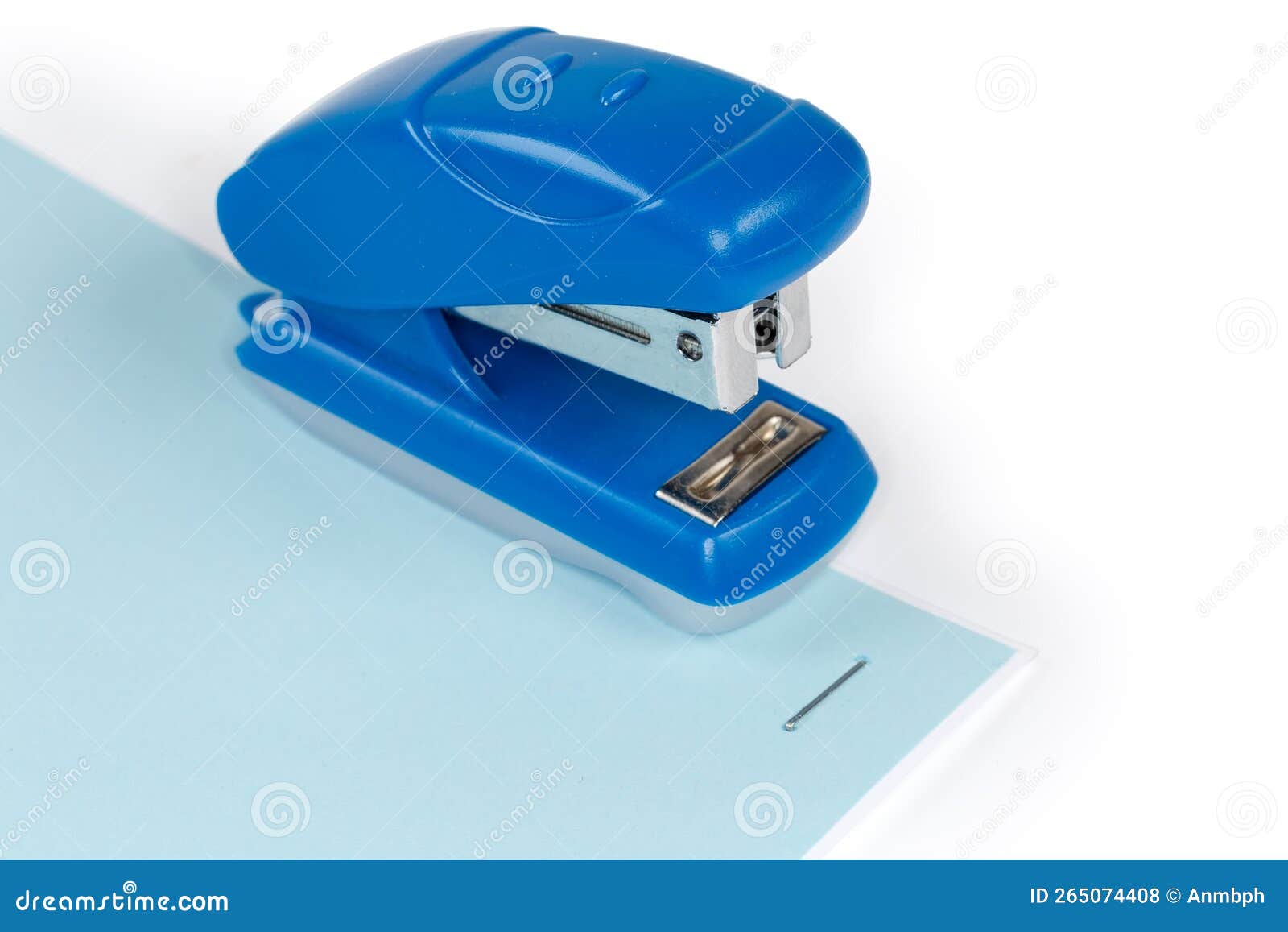 Small Paper Stapler on a Stapled White and Blue Sheets Stock Photo