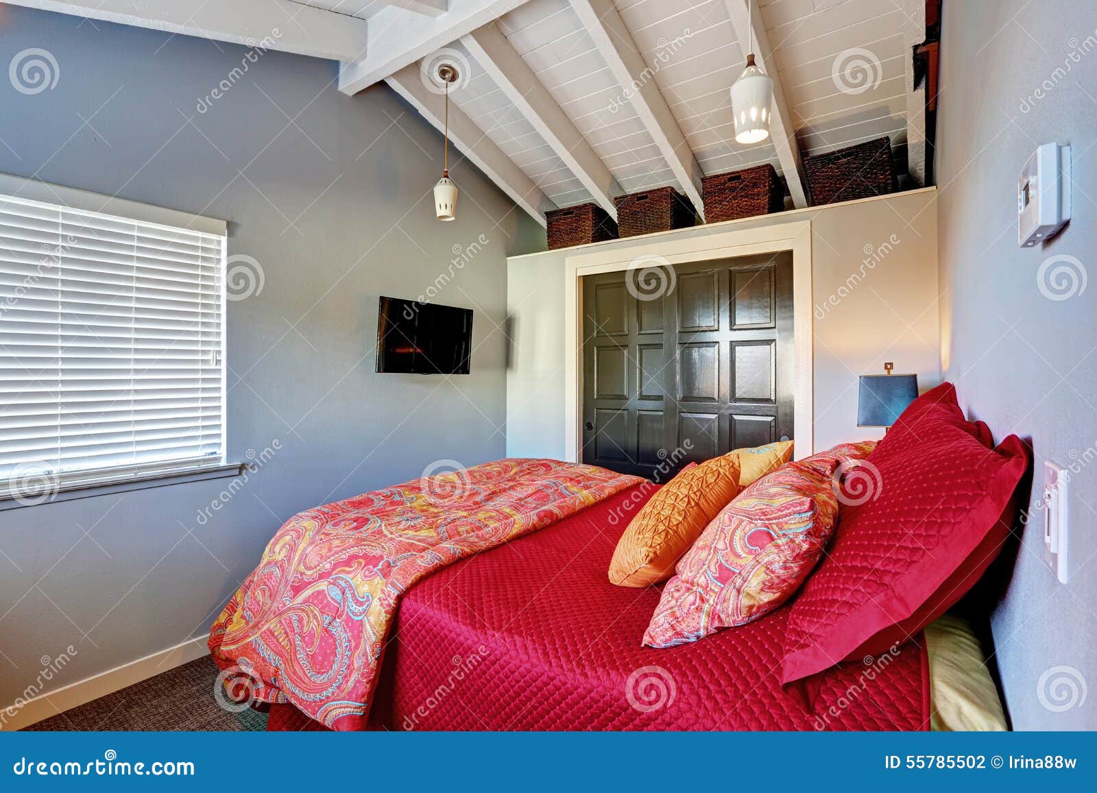 Small Perfect Bedroom with Red Bedding and Grey Walls. Stock Photo