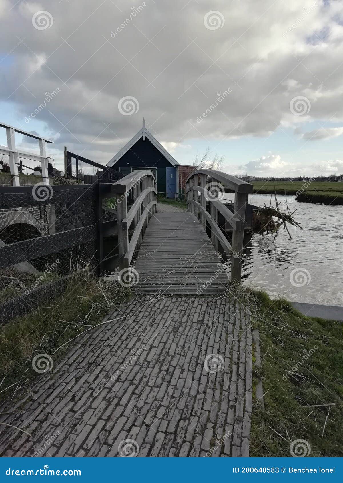 small rustic wooden bridge over the river in kinderdijk