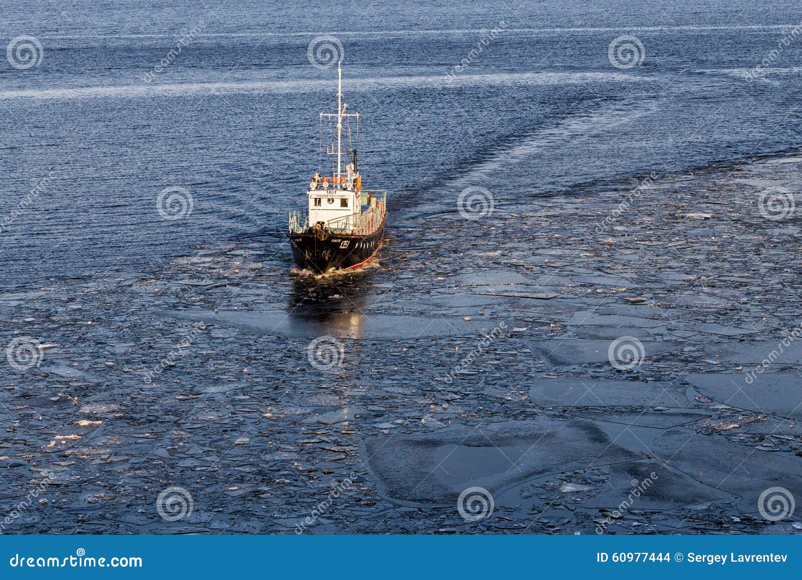 Small ship floating in the water among the ice floes Editorial Stock 