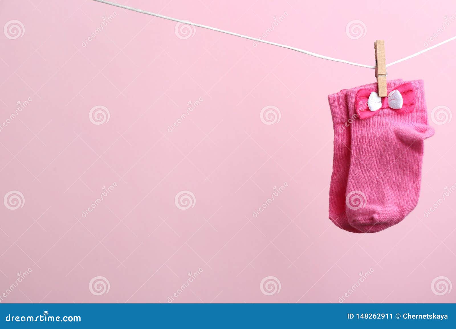 Small Socks Hanging on Washing Line Against Color Background. Baby ...