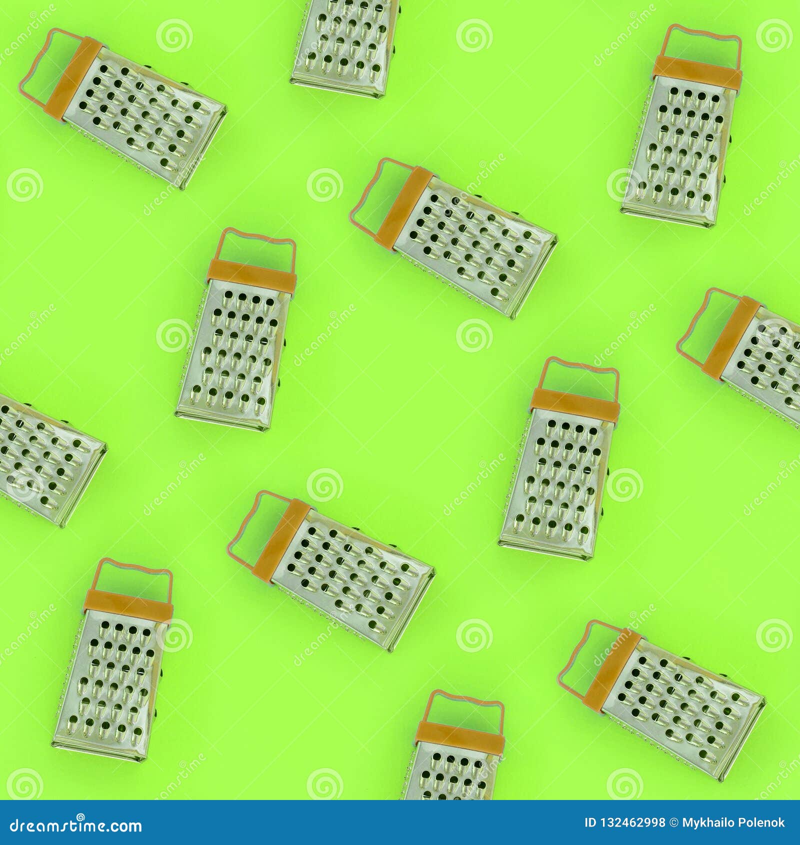 Small stainless steel graters lies on a pastel colored paper. Kitchen accessories. Tools for cooking. Flat lay top view