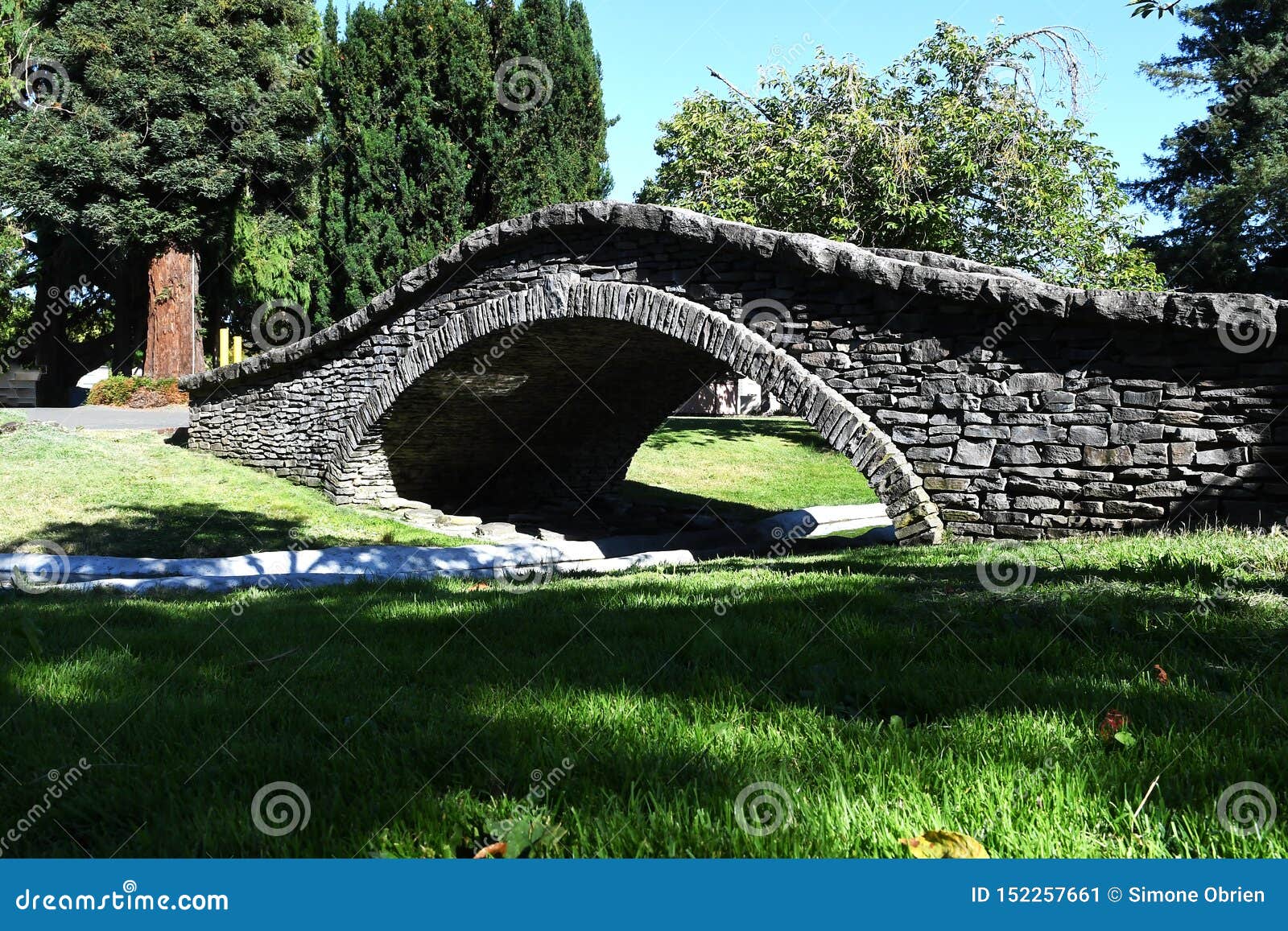 small stone viaduct bridge in a local park across small river in santa rosa, california