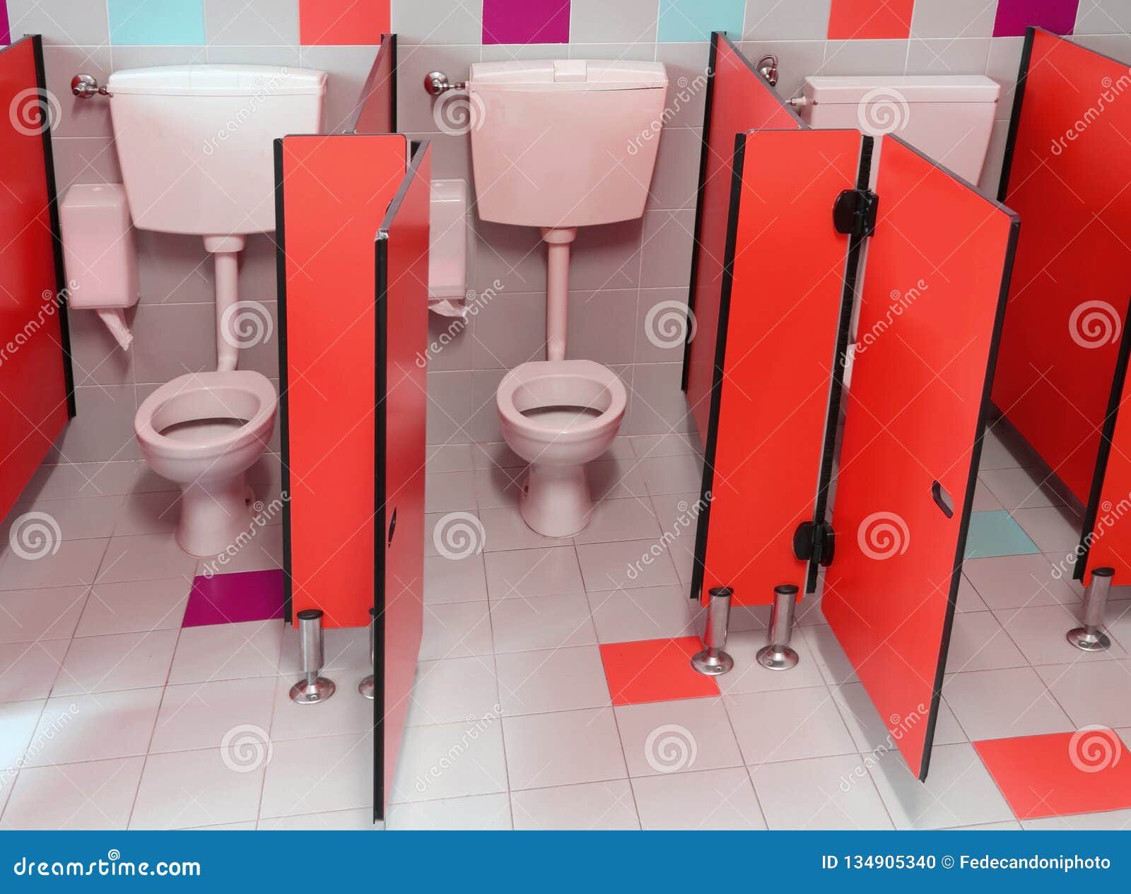 Small Toilets with Red Doors for Children in a Kindergarten Stock Photo