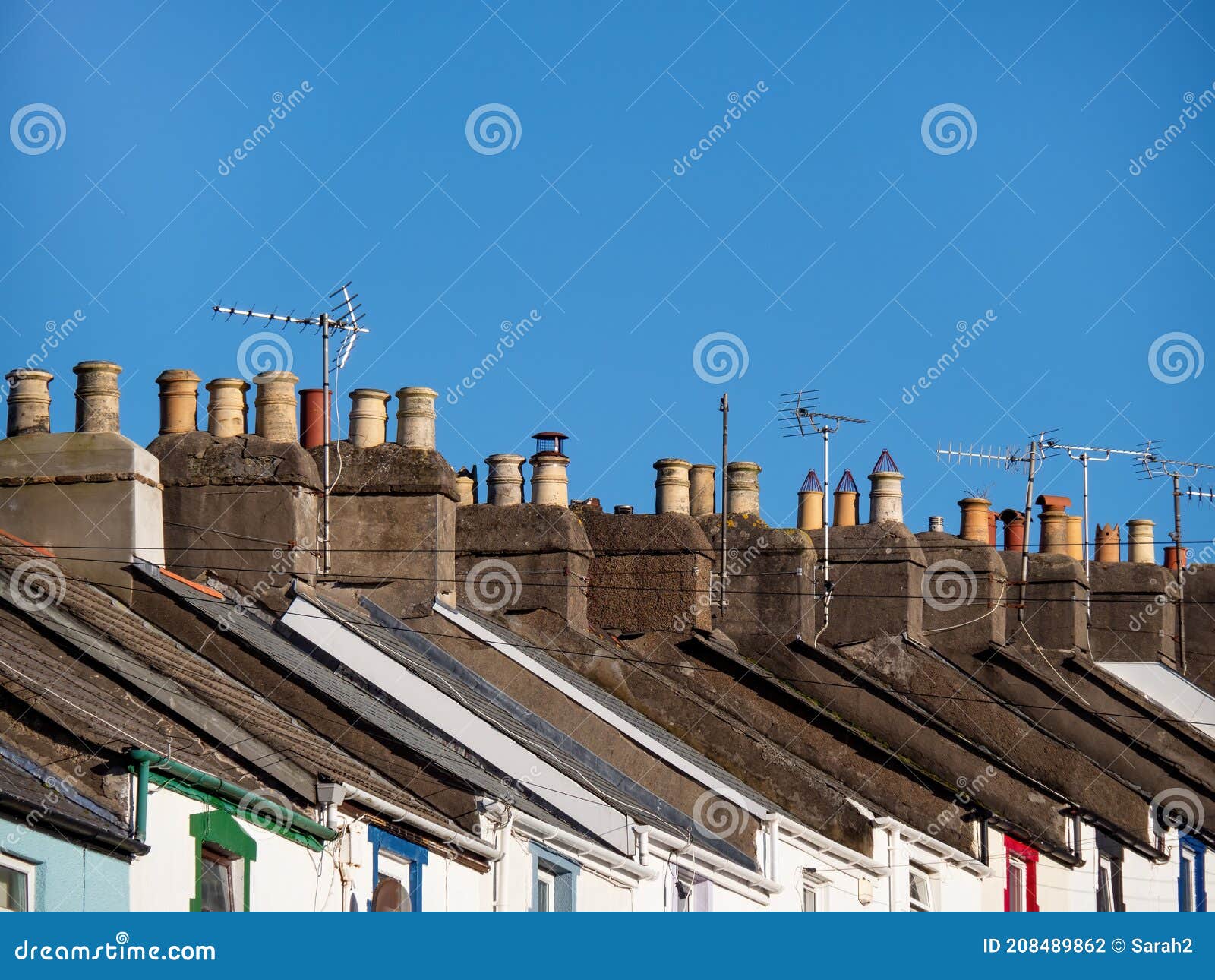 small town house rooftops, england, uk. aerials and blue sky.