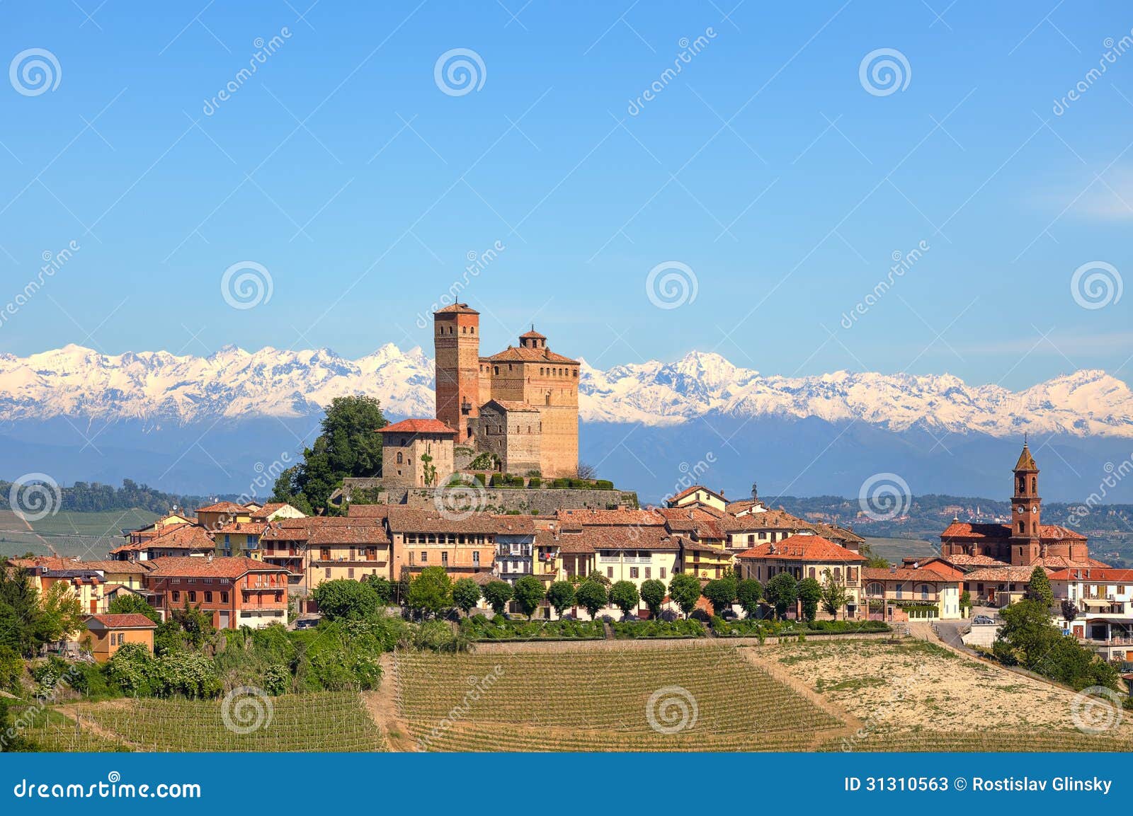small town with old castle on the hill in piedmont, italy.