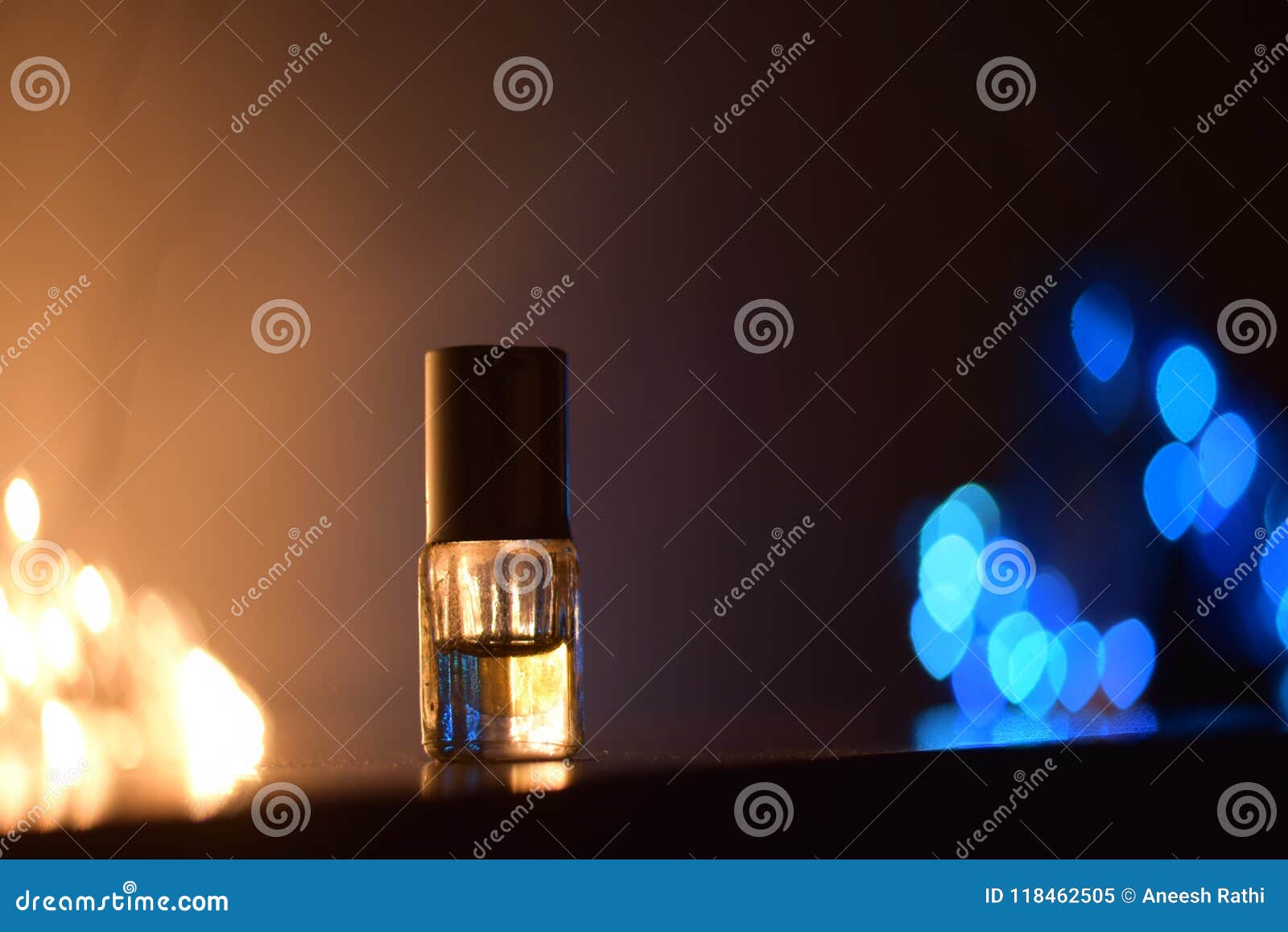 small glass bottle with perfume and bokeh background