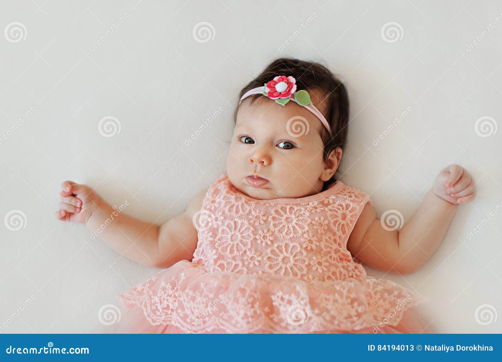 Small Very Cute Wide-eyed Smiling Baby Girl in a Pink Dress Lying ...