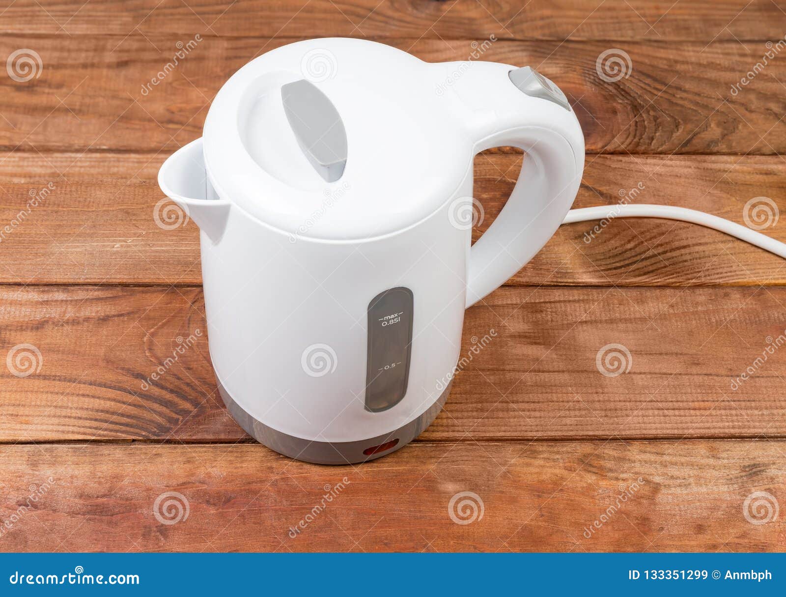 Small White Plastic Electric Kettle on an Old Wooden Table Stock