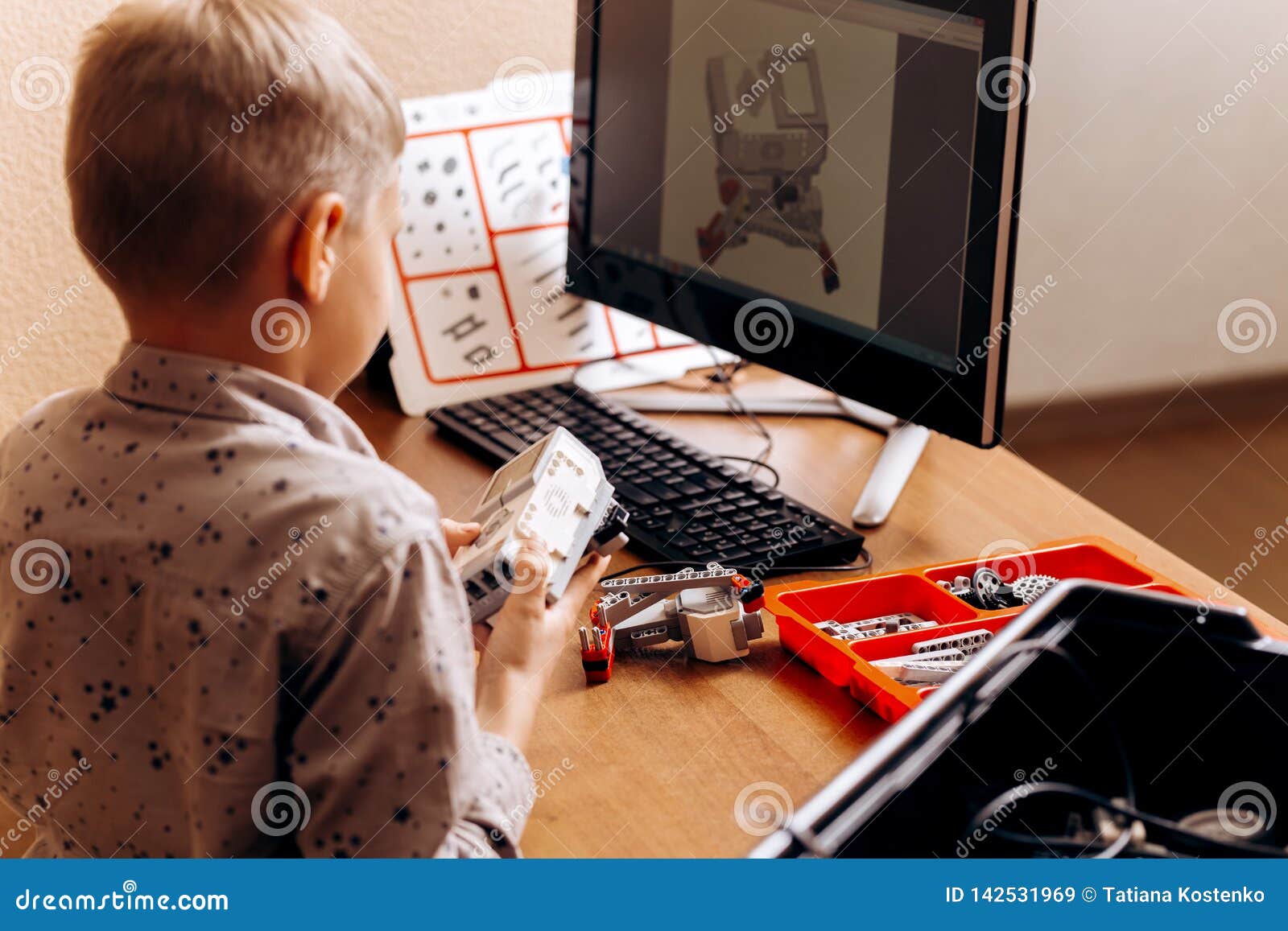 Smart Boy Dressed In Gray Shirt Makes A Robot From The Robotic