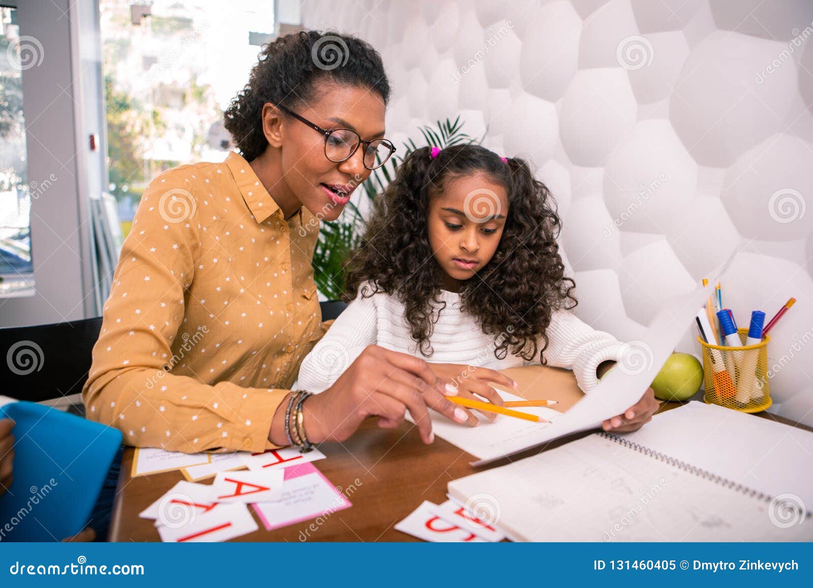 Smart Caring Teacher Teaching Cute Preschool Girl Reading and Writing