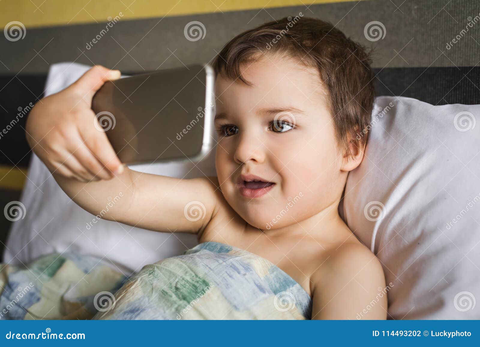 Smart Cute Boy Taking Selfie on Phone Lying on the Bed in Morning Stock  Photo - Image of network, application: 114493202