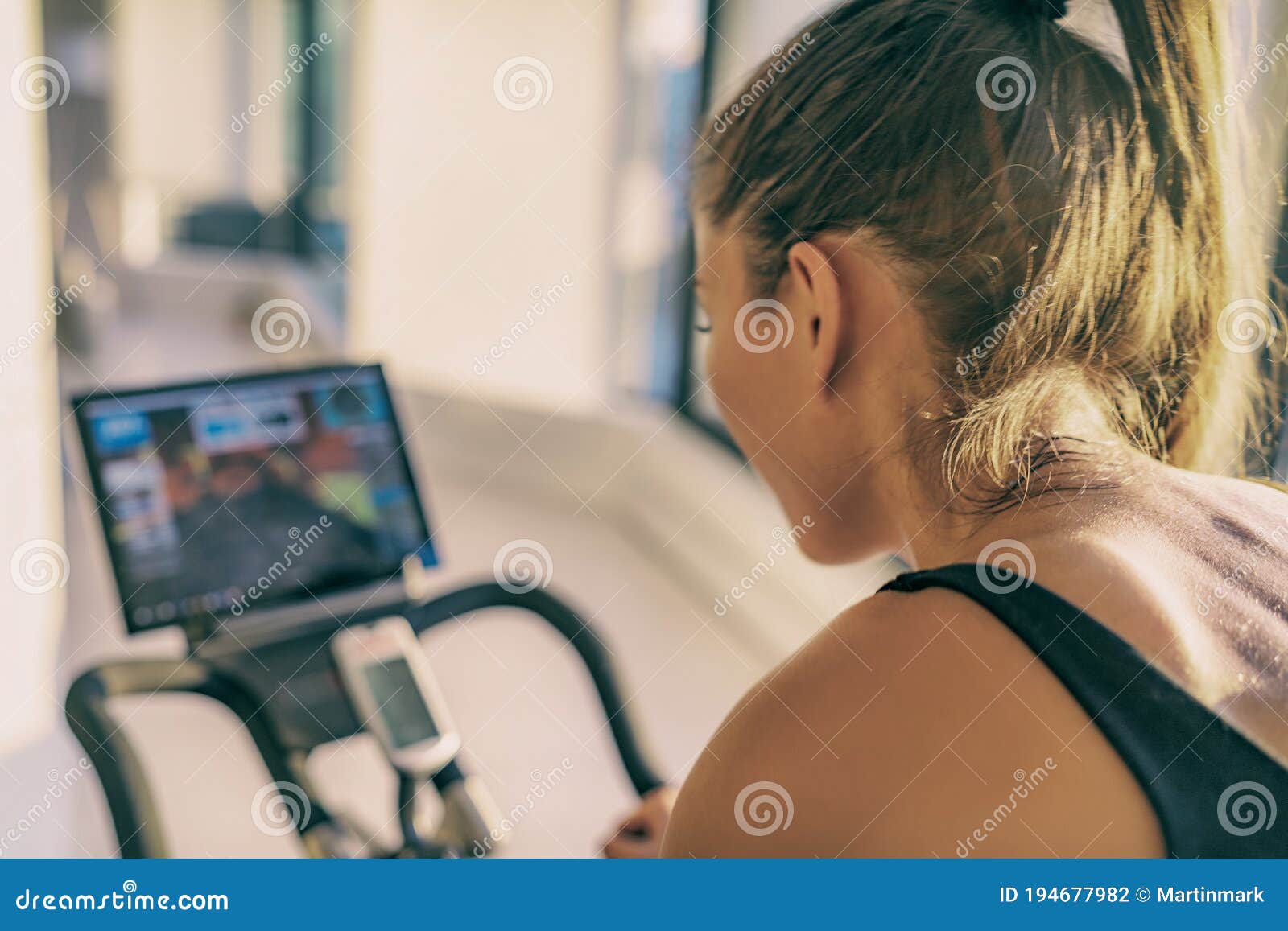 Smart Fitness Home Workout Biking Screen with Online Classes Woman Training on Stationary Bike Equipment Indoors for Stock Photo
