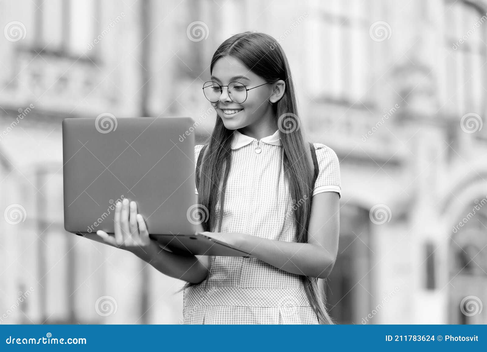 smart looking kid in gasses typing on computer searching information in internet for online school education, childhood