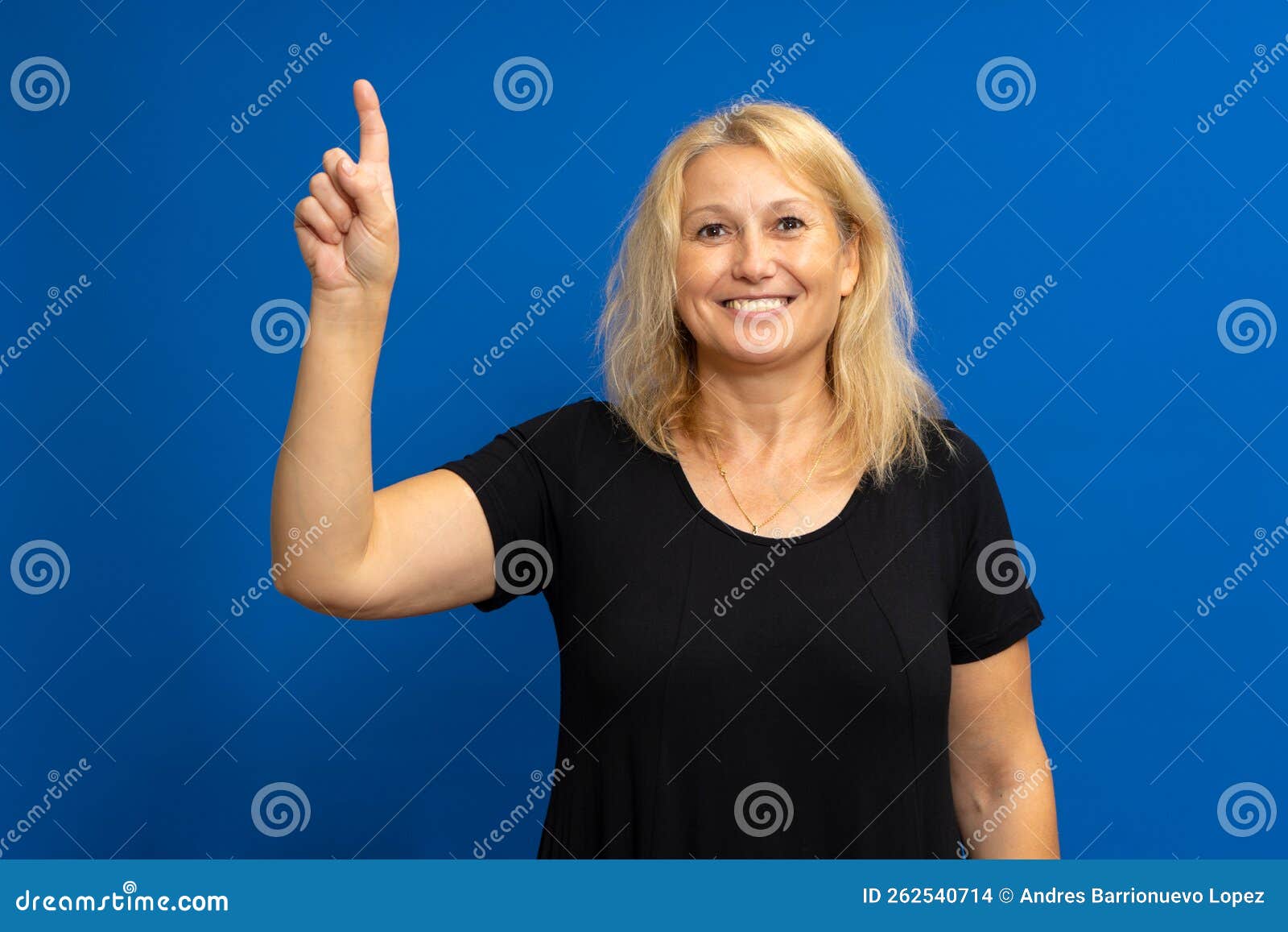 smart proactive 40 years old woman in black t-shirt holding up index finger with great new idea  on blue colored
