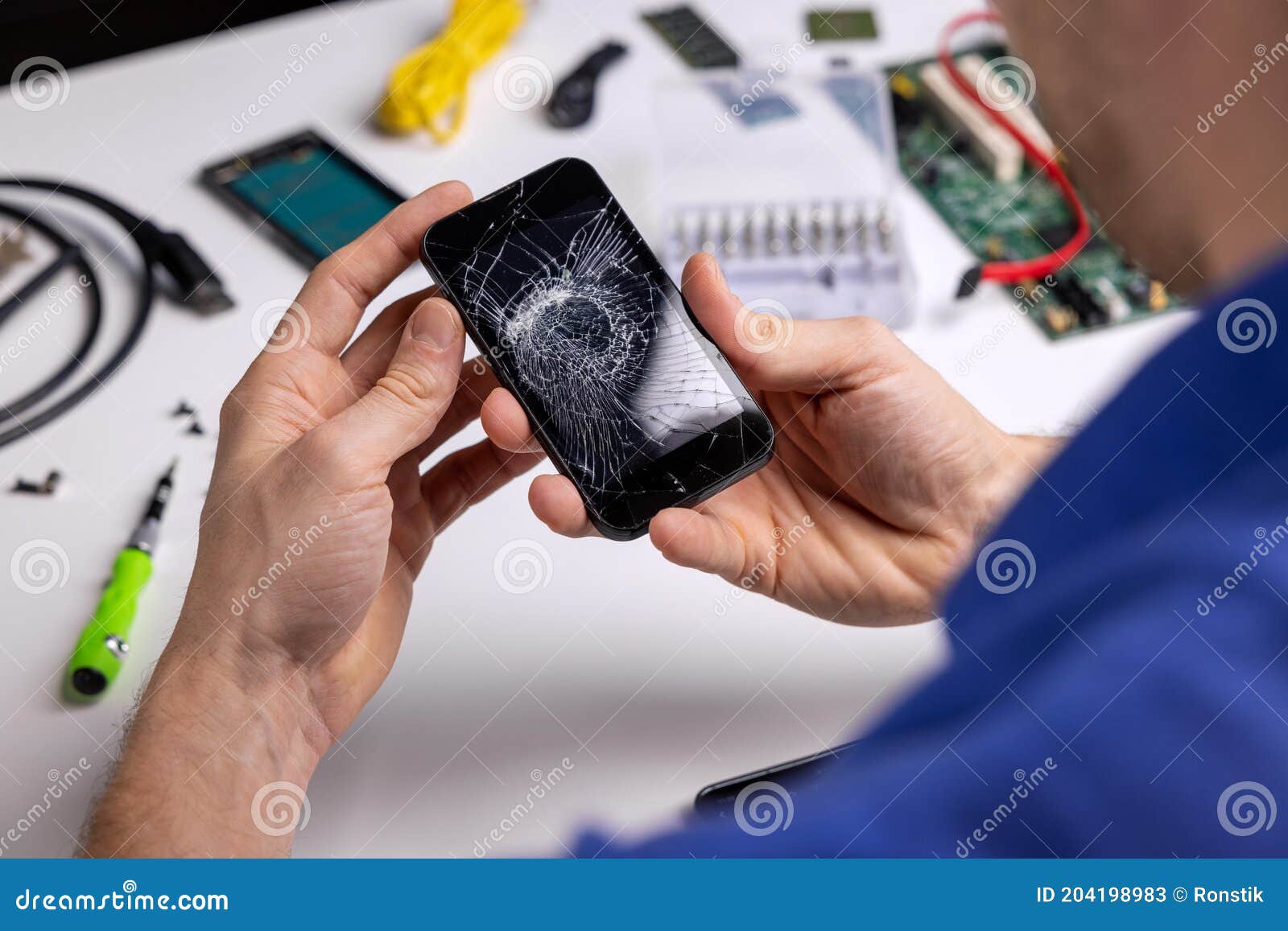 smartphone with broken cracked screen in technician hands. phone repair service