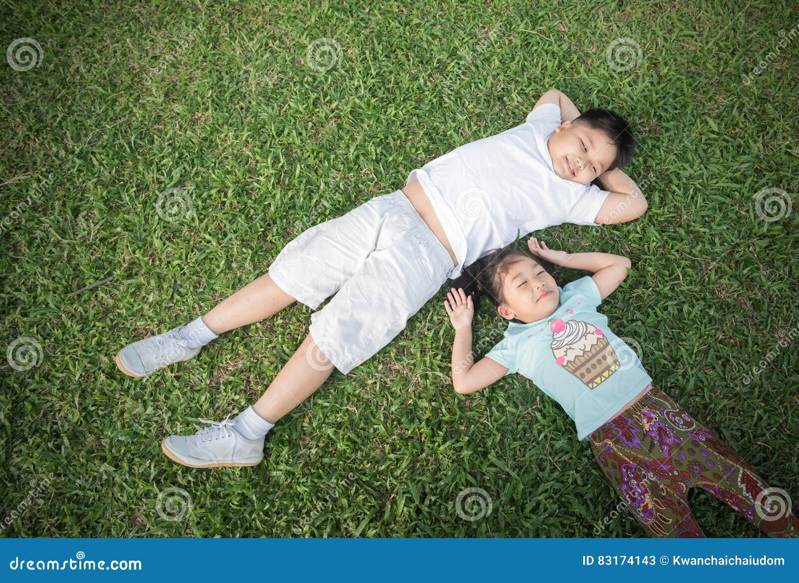 smile children lie down on grass