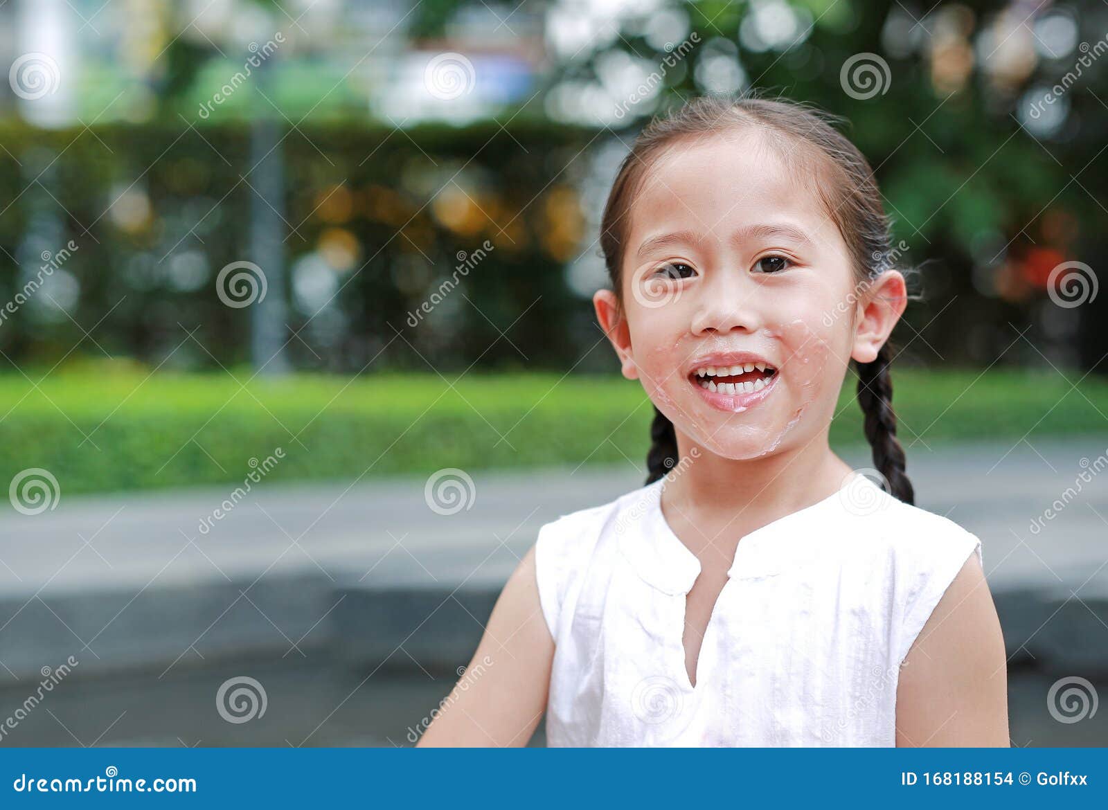 Smiling Asian Little Girl Eating Bread With Stuffed Strawberry