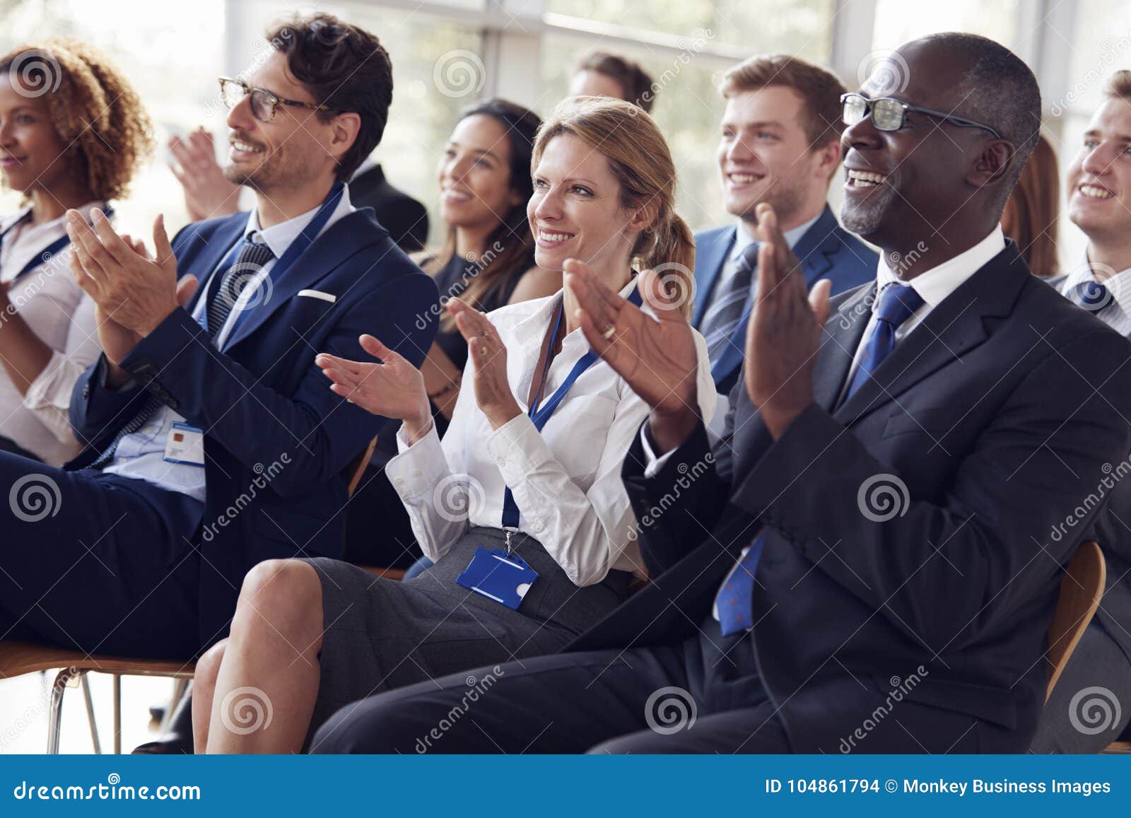 smiling audience applauding at a business seminar