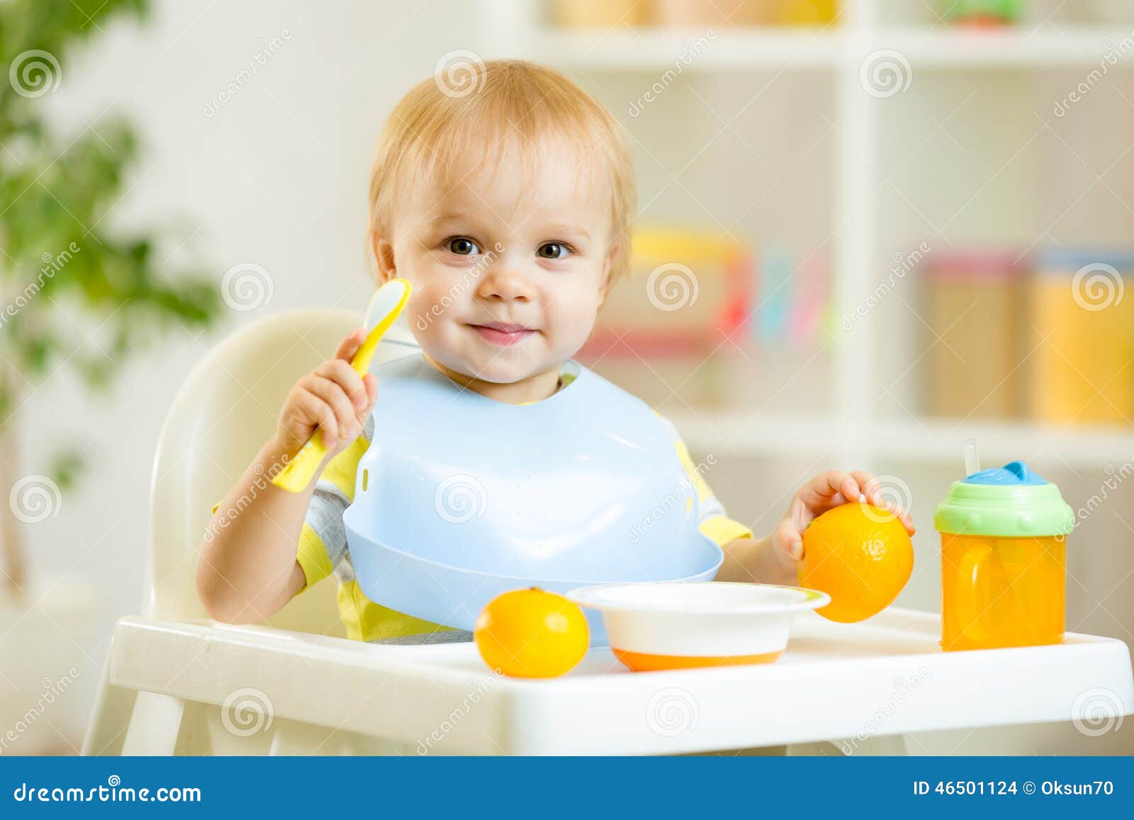 smiling baby child boy eating itself with spoon