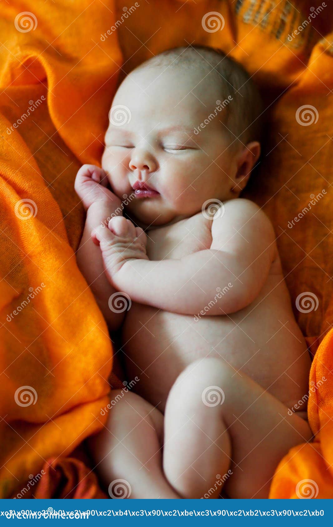 Smiling Baby with a Rattle on a Pretty Orange Background Stock Image