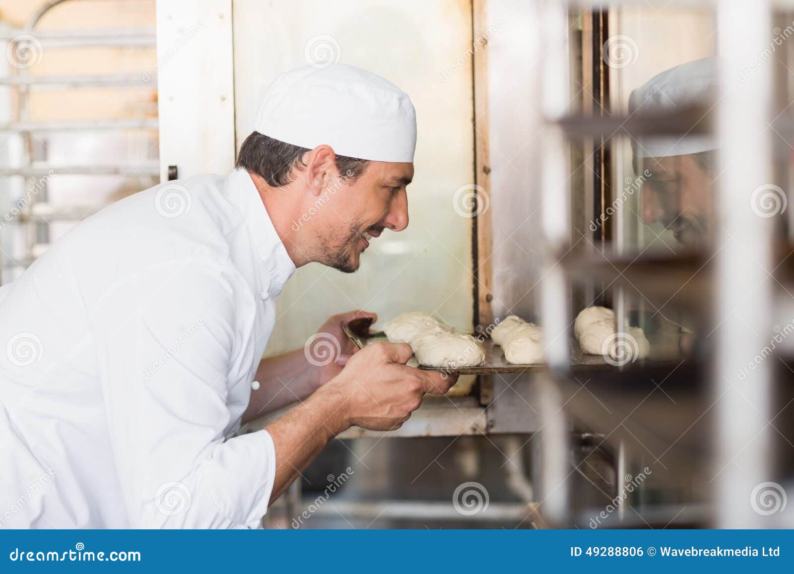 Baker Putting Croissant On Paper In Tray For Baking In Oven On Bakery