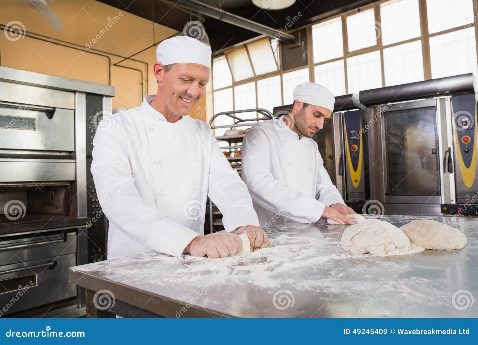 Smiling Bakers Kneading Dough at Counter Stock Image Image of