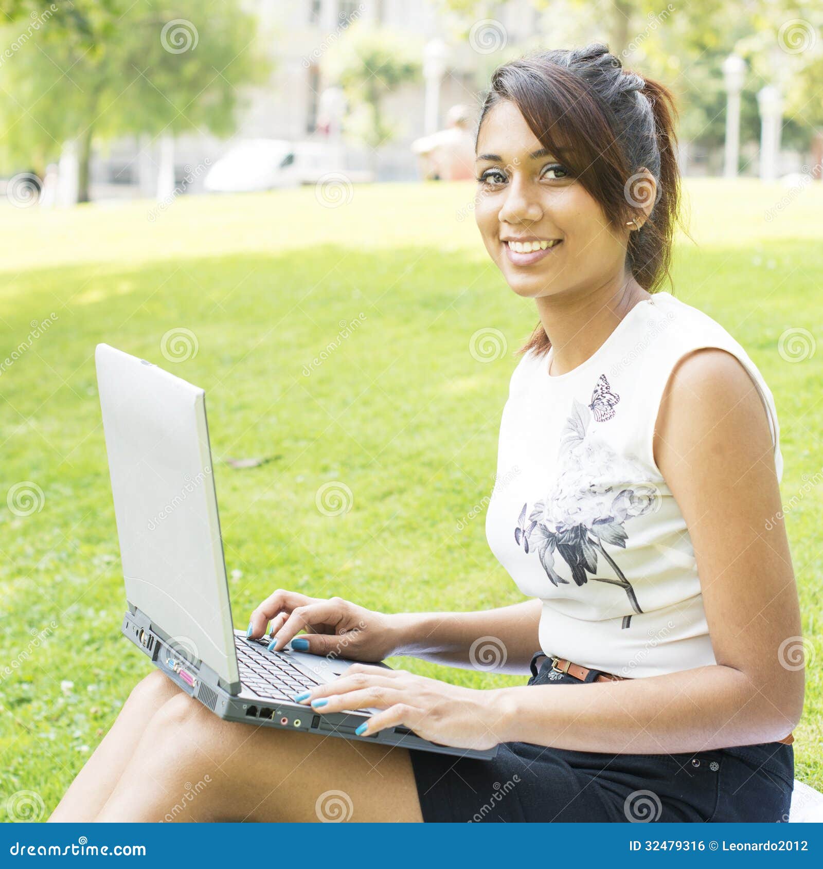 smiling beautiful woman with cmputer in the park.