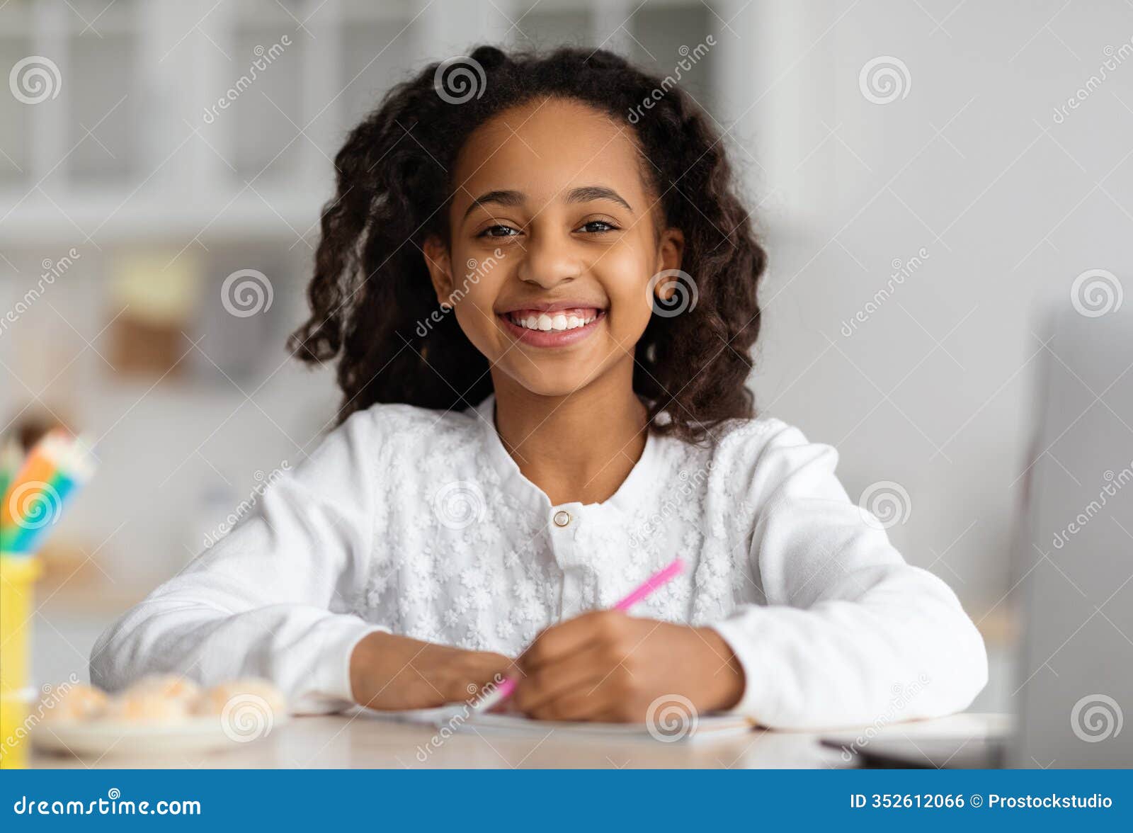 smiling black girl studying online, using laptop at home